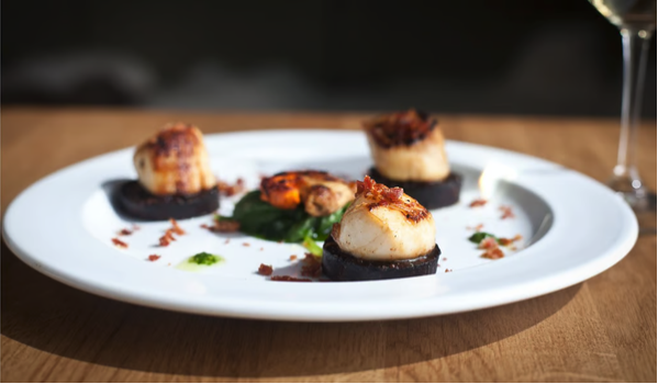 A plate of grilled scallops on black pudding, served at The Black Pig, Kinsale, Ireland