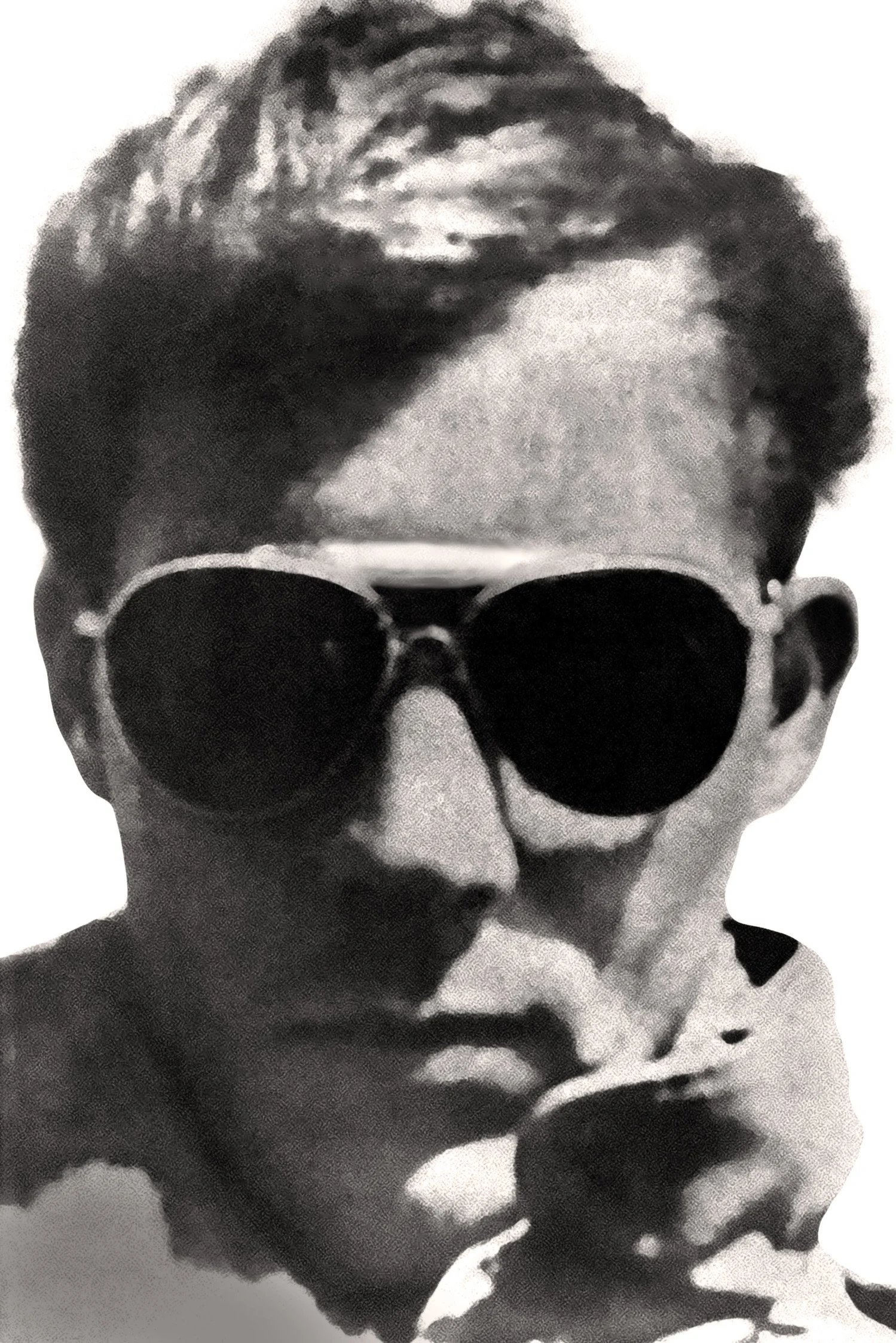A black and white photo of a person wearing sunglasses and short hair, with a blurred background.