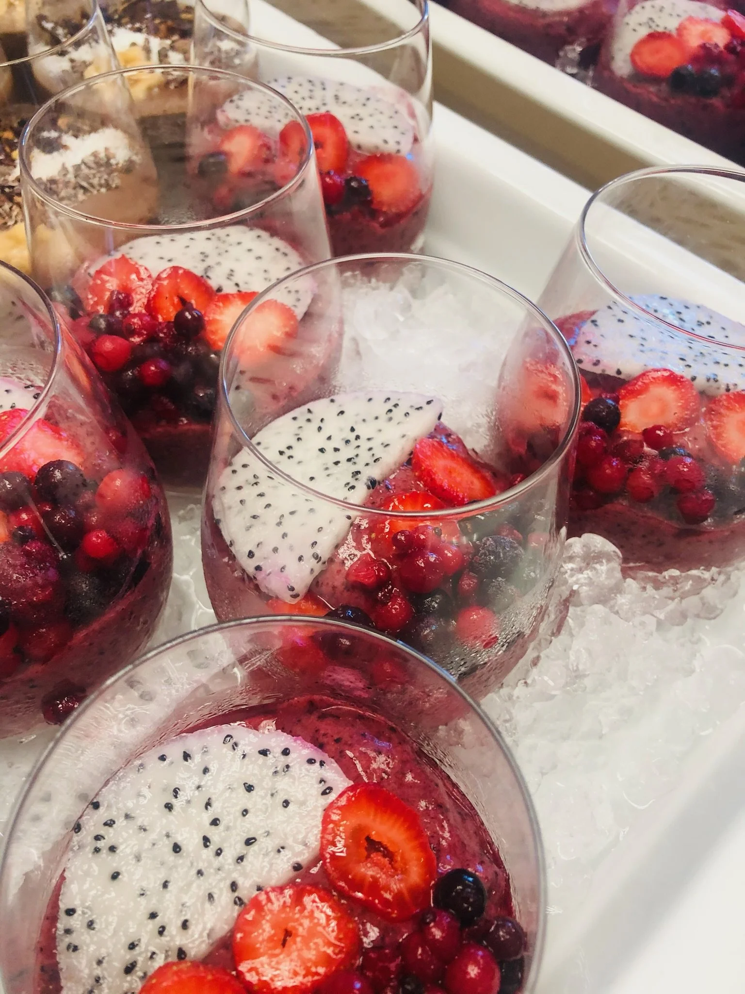 Glasses of berry and dragon fruit dessert on ice