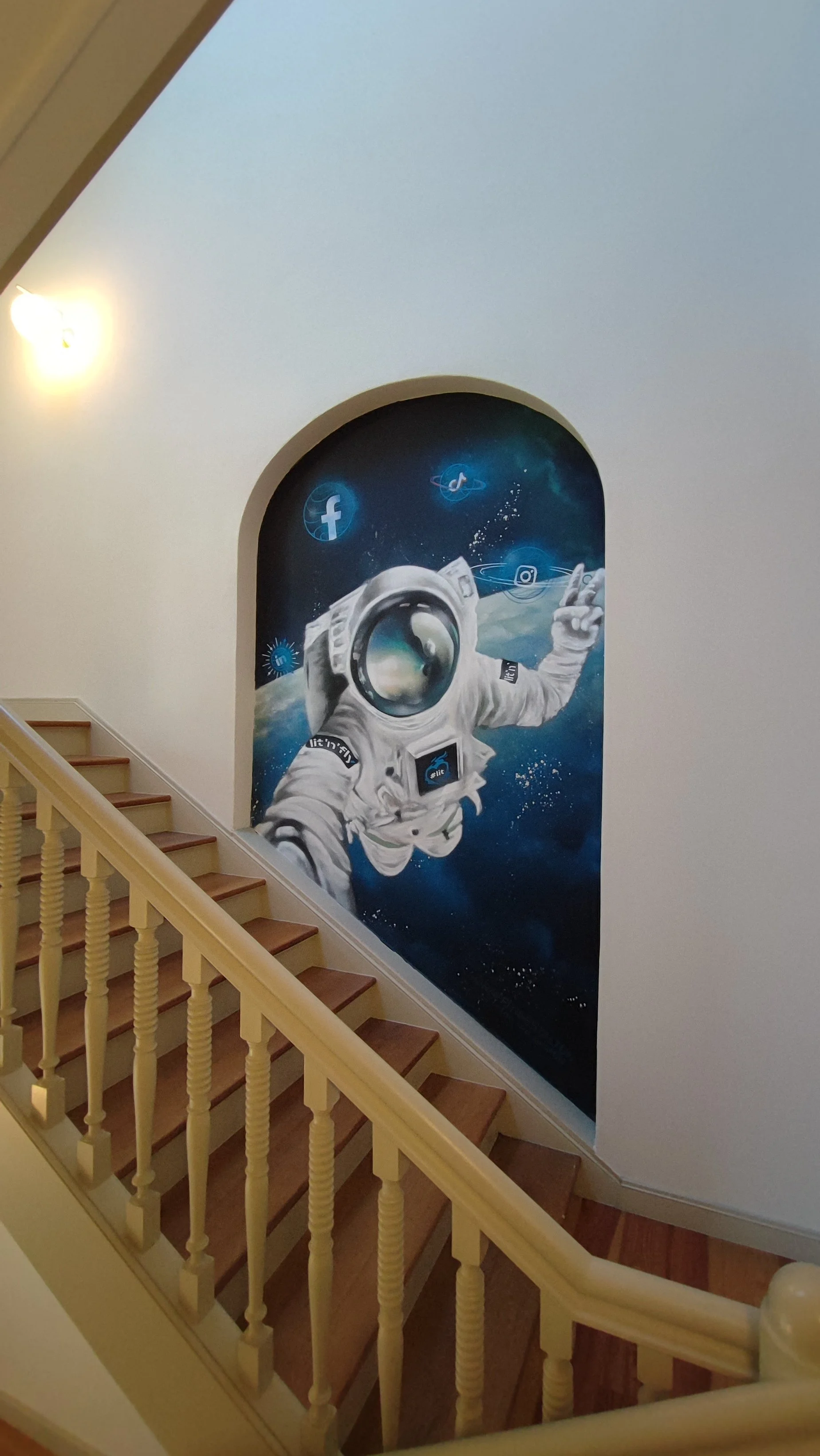 Wandgemälde eines Astronauten, der im All schwebt, mit sozialen Medien Logos wie Facebook, TikTok, Twitter und Instagram im Hintergrund. Professionelle Graffitigestaltung in Dresden: individuelle Wandgestaltung, Auftragsgraffiti sowie kreative Graffi