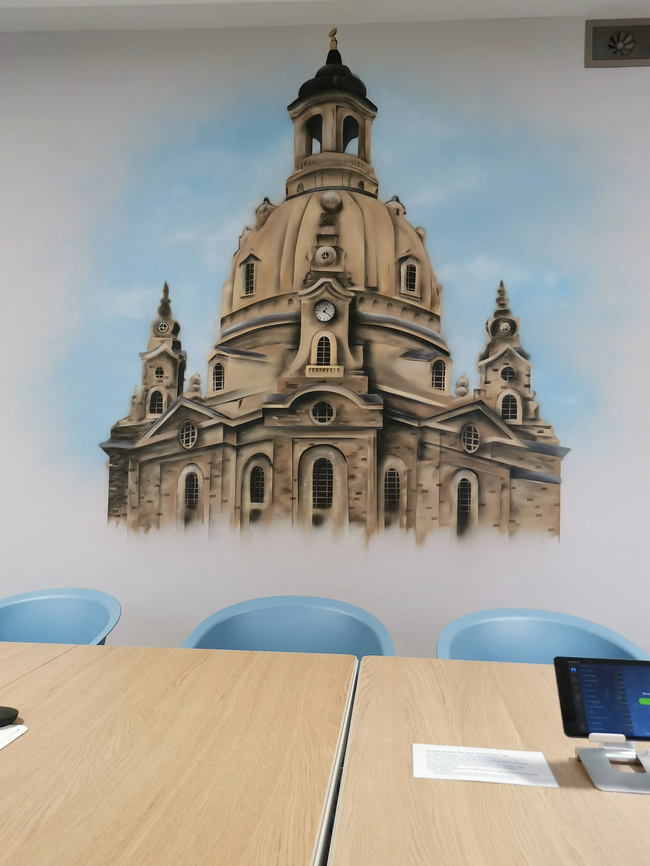 Wandkunst in einem Raum, die eine große Kirche mit einer Kuppel und Türmchen zeigt, gemalt im Wanddesign.