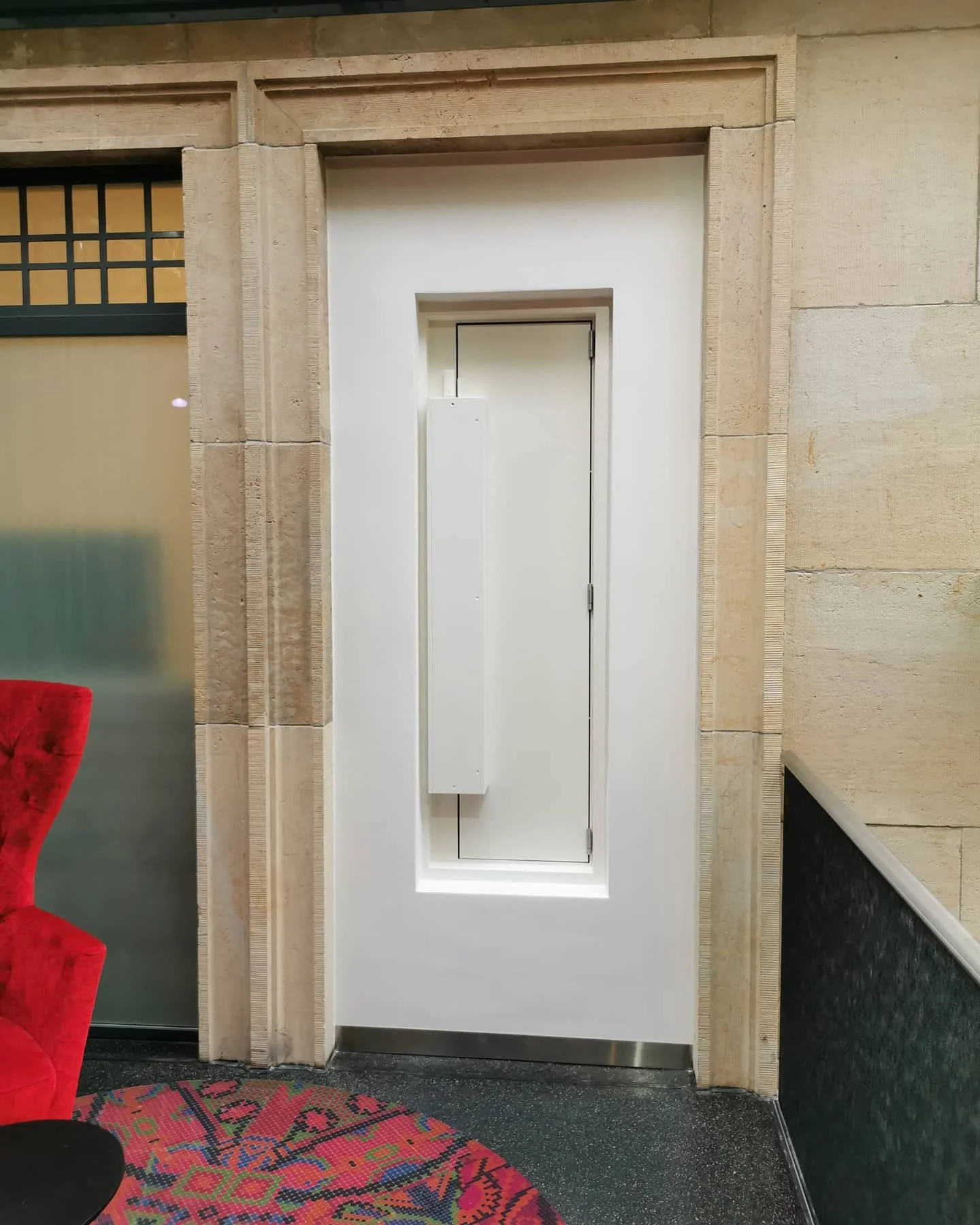 Schrank oder elektrisches Panel in einem weißen Nische an einer Wand mit einer Tür davor