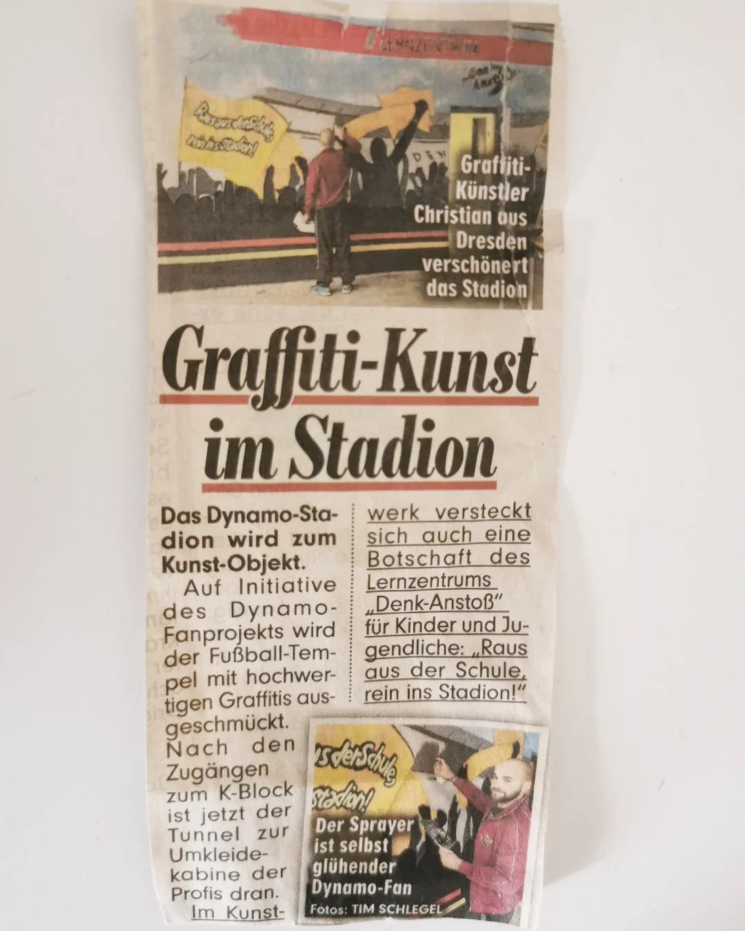 Zeitungsartikel über Graffiti-Kunst im Stadion, mit Fotos von Graffiti-Künstler Christian aus Dresden, der eine Stadionwand gestaltet.