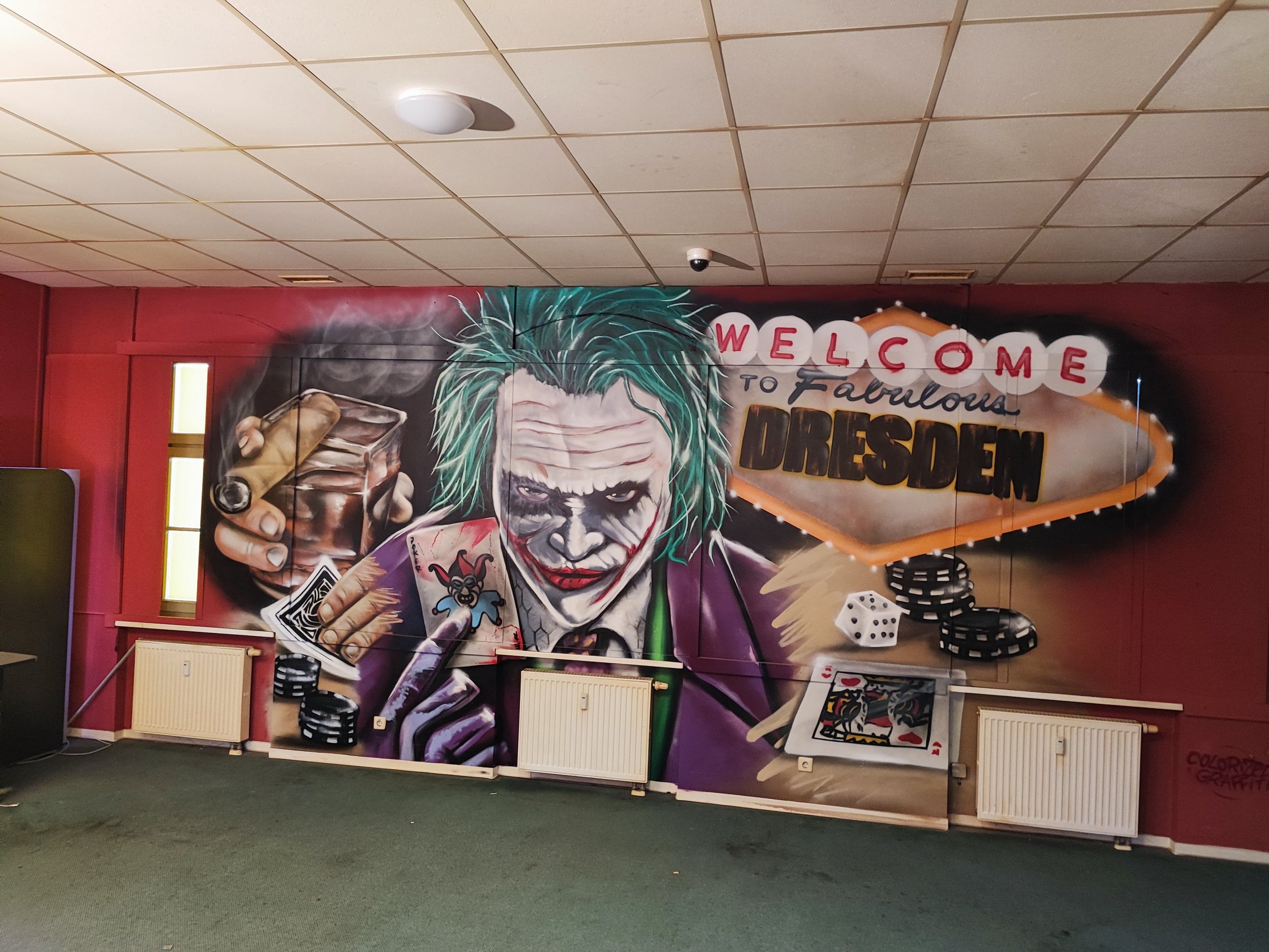 Graffiti Wand mit Joker-Graffito, Welcome zu Dresen, Spielkarten, Würfel und Pokerchips.