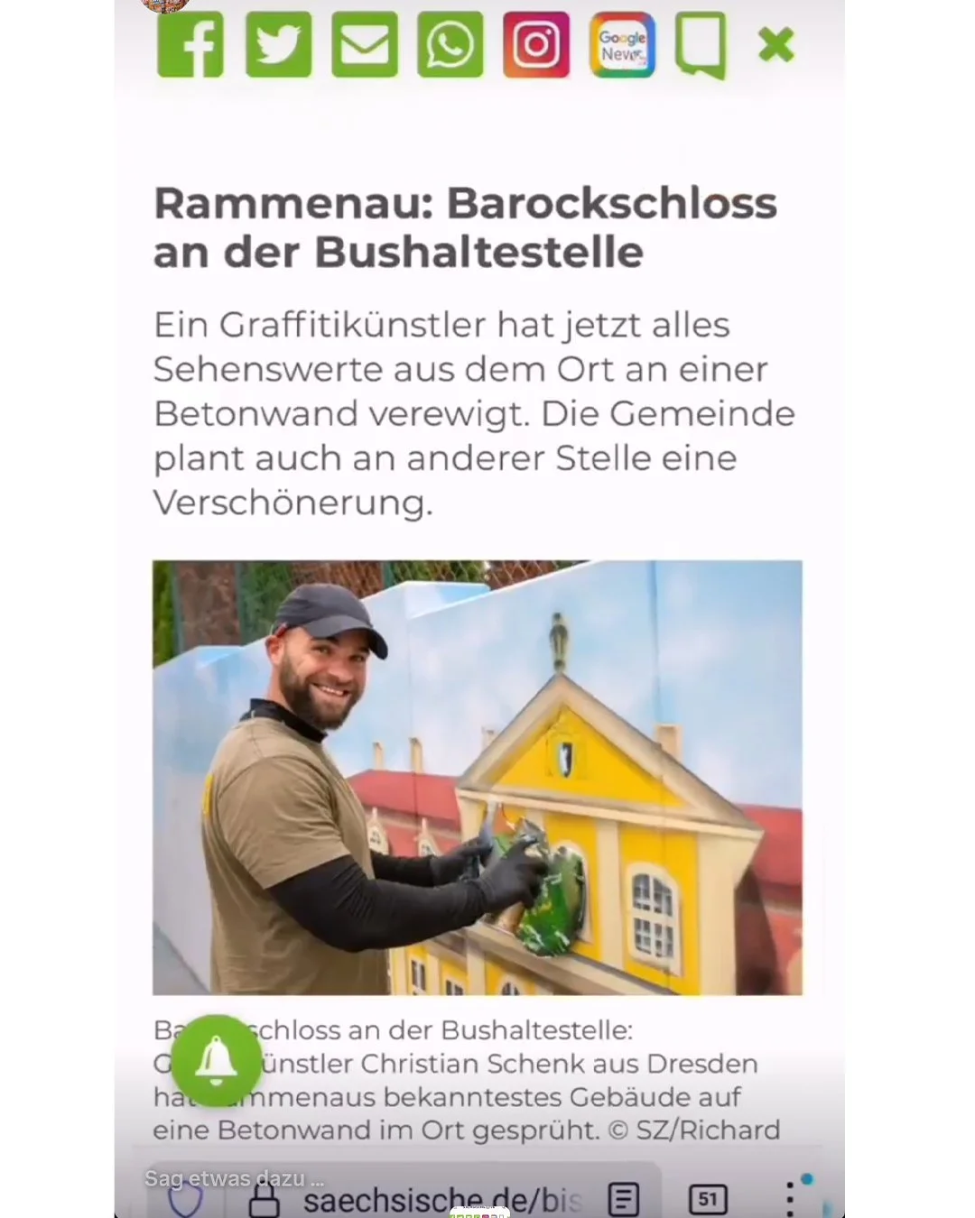 Ein Mann, der Graffiti an einem Gebäude malt, das aussieht wie ein farbiges, plastisches Haus. Im Hintergrund ist eine Wand zu sehen.