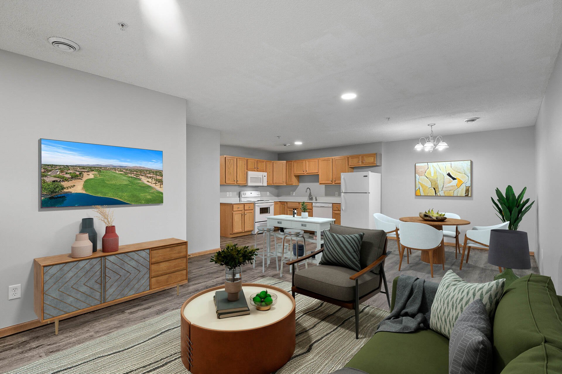 Living room with a houseplant, couch, armchair, TV, and decor, opening to a kitchen with wooden cabinets, white appliances, and a dining table with chairs.