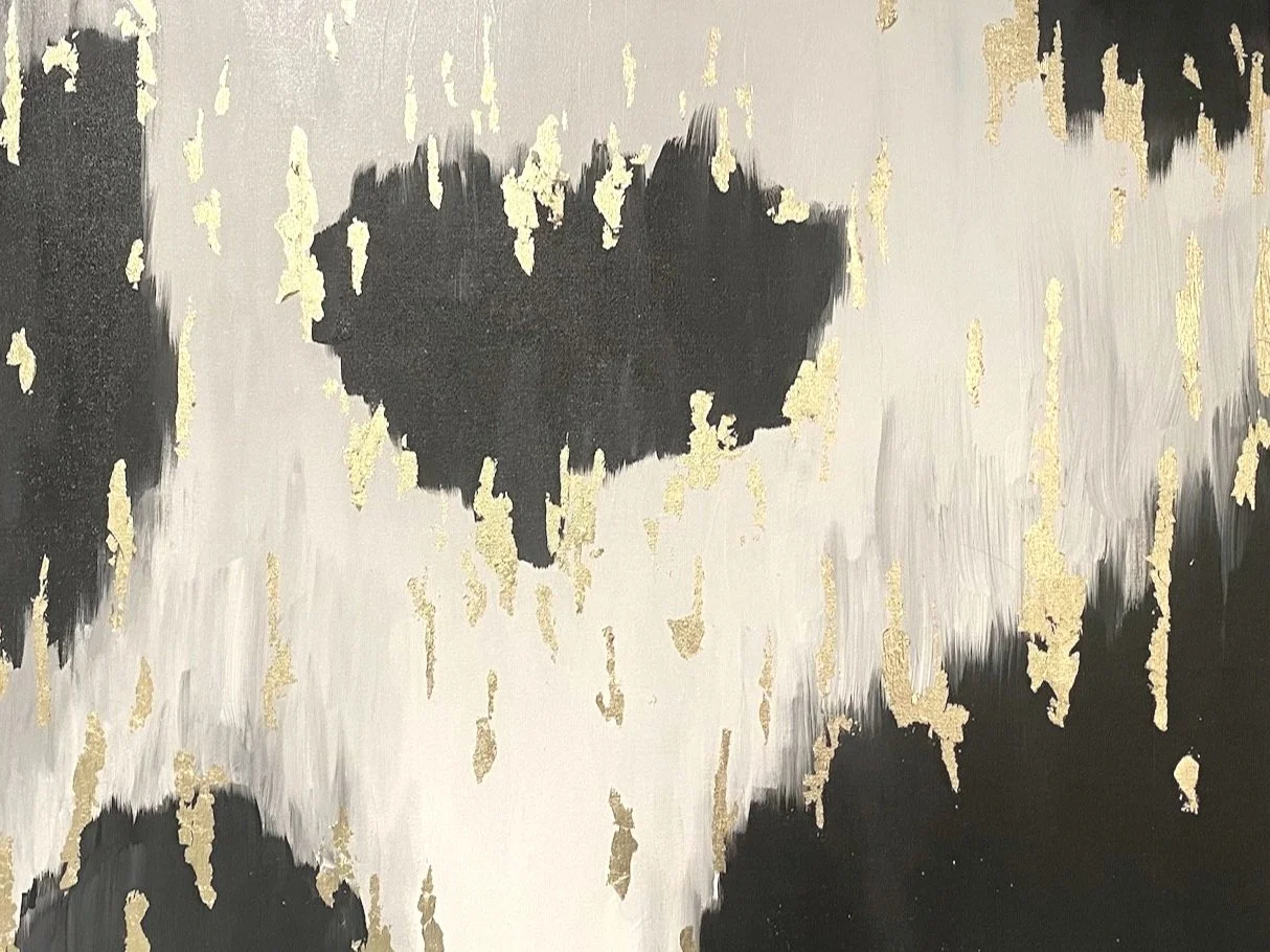 Abstract painting with black and white brush strokes and gold leaf accents.