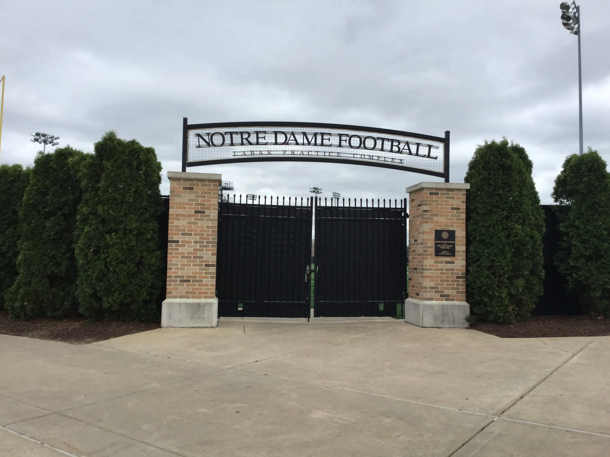 Notre Dame Football LaBar Practice Complex metal entrance sign above black gates