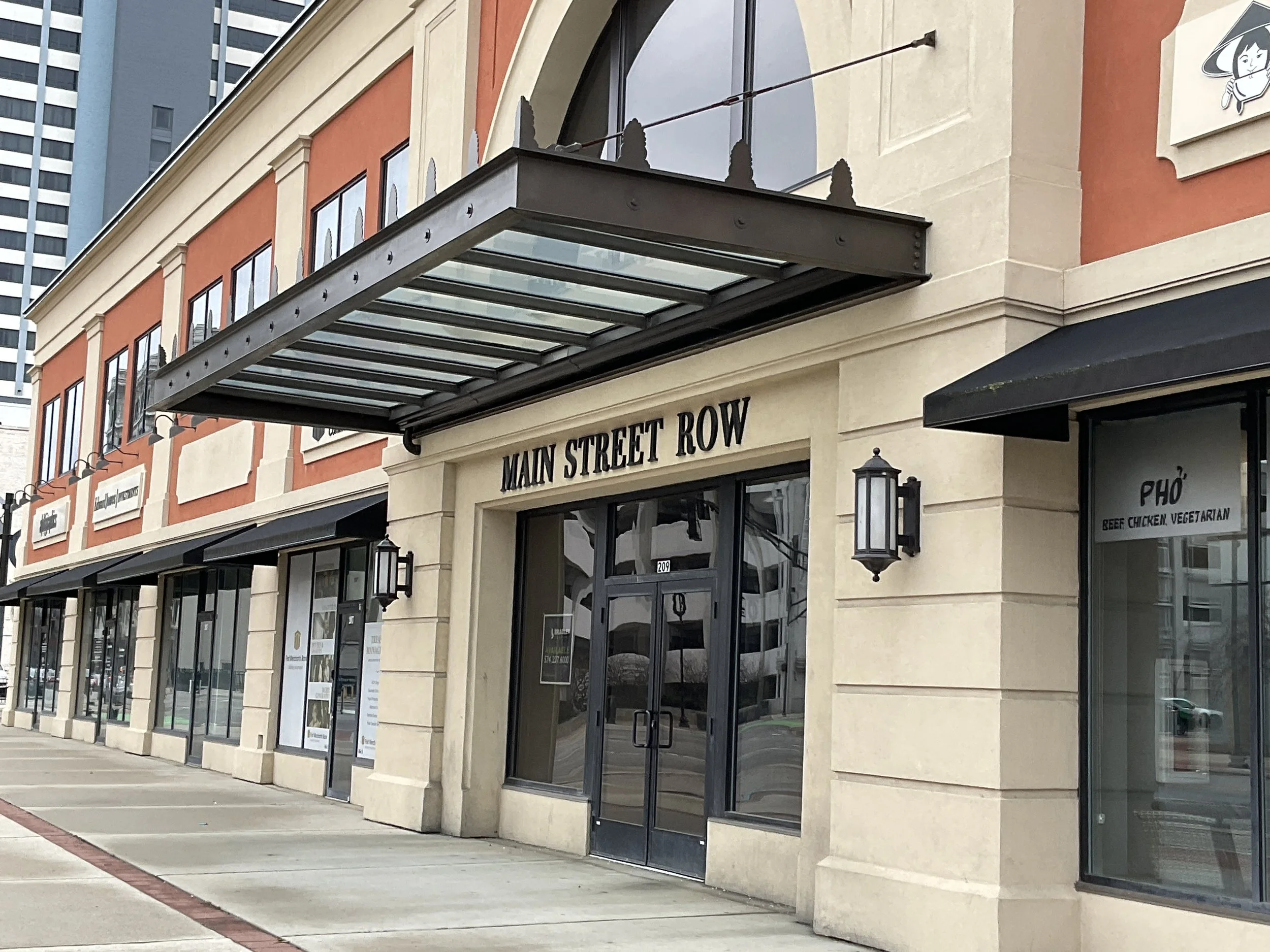 Exterior metal canopy integrated into a multi‑story commercial building.