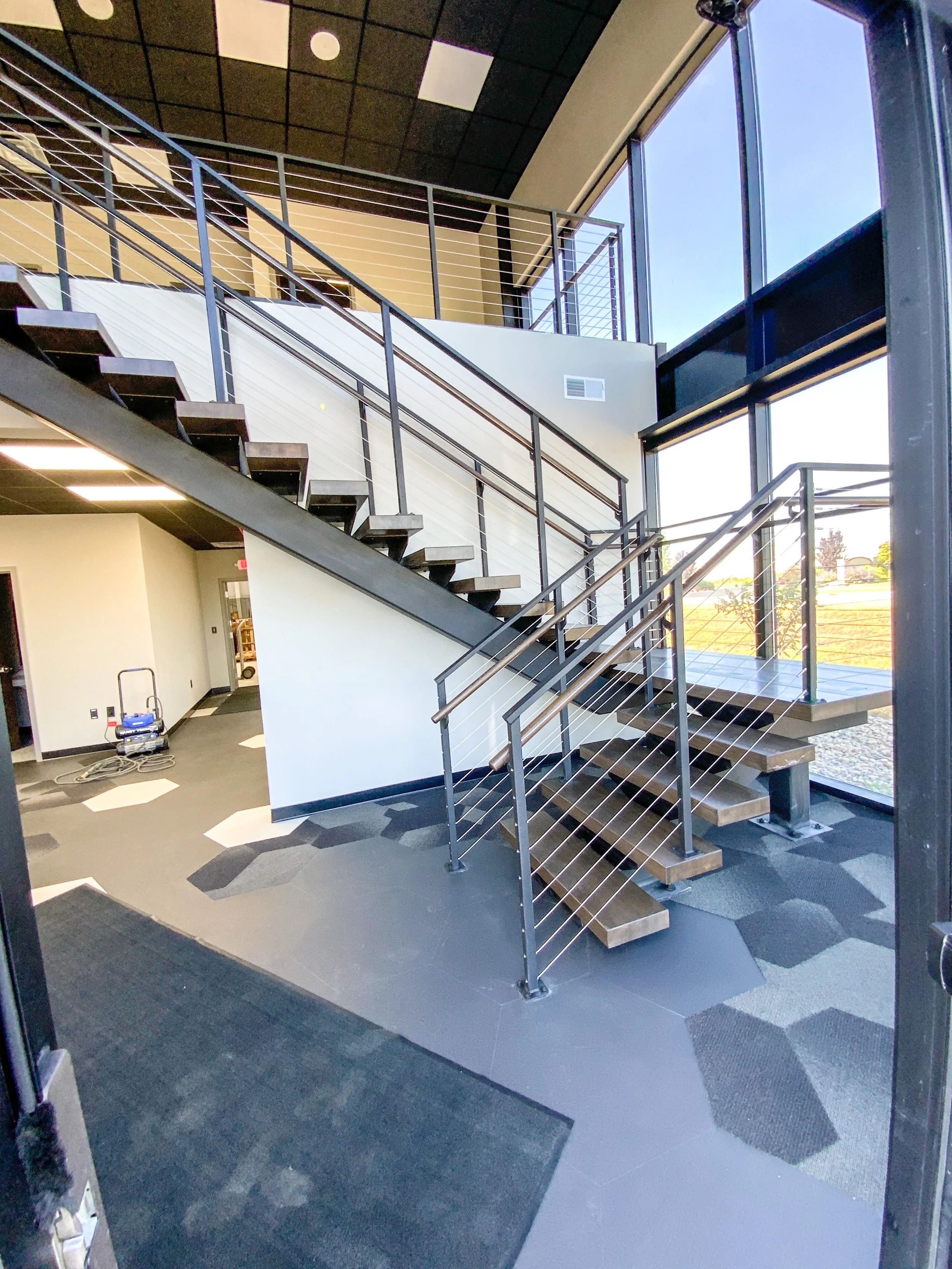 Interior stairway with metal handrails and wood steps.