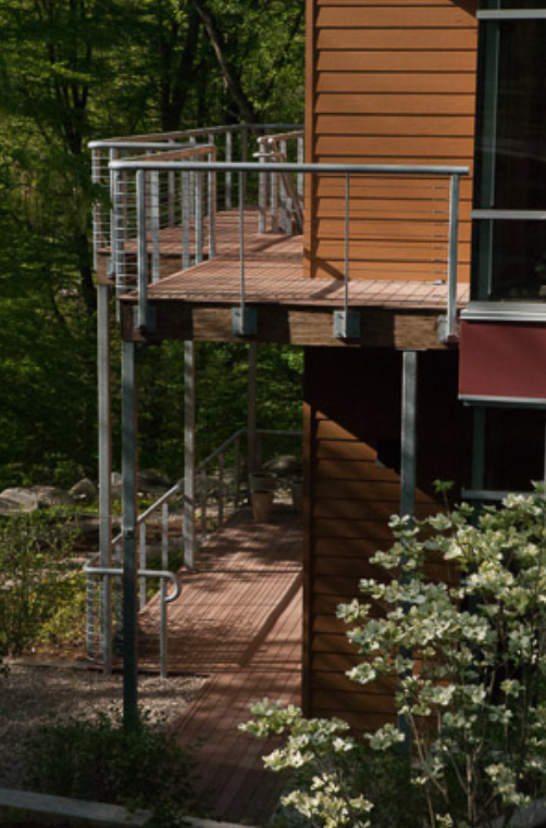 Elevated Deck Walkway with Custom Cable Railings Extending Along the Building Edge.