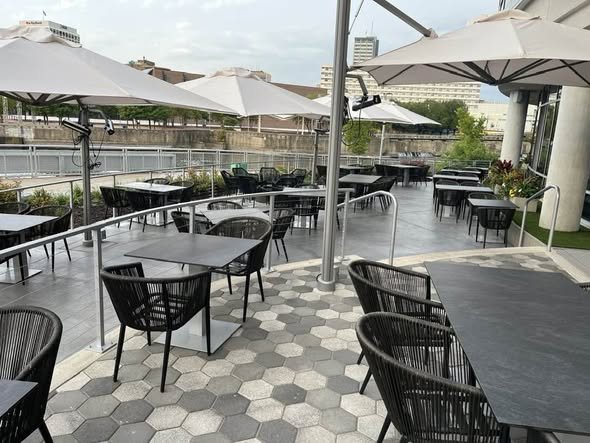 Curved Exterior Metal Railing System Defining Cascade's Waterfront Patio Dining Area.