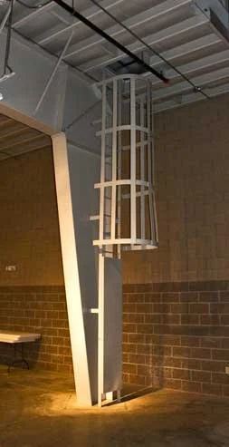 Custom fabricated metal step ladder installed in interior space.