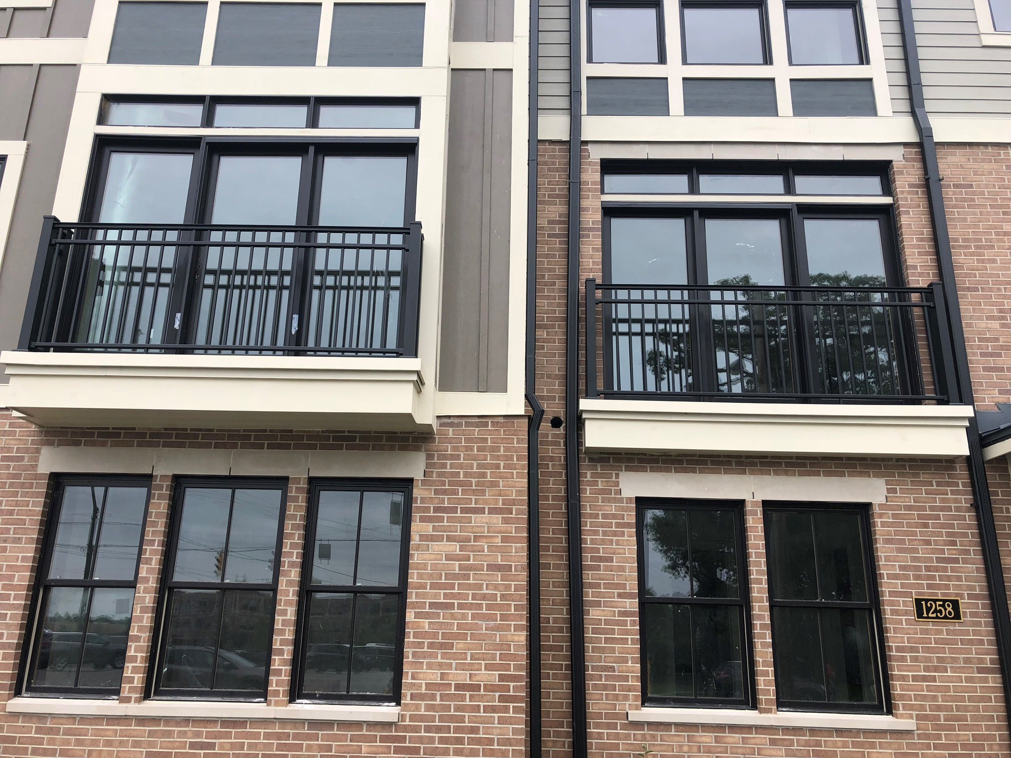 Custom Metal Balcony Railings Integrated into the Townhouse Façades.