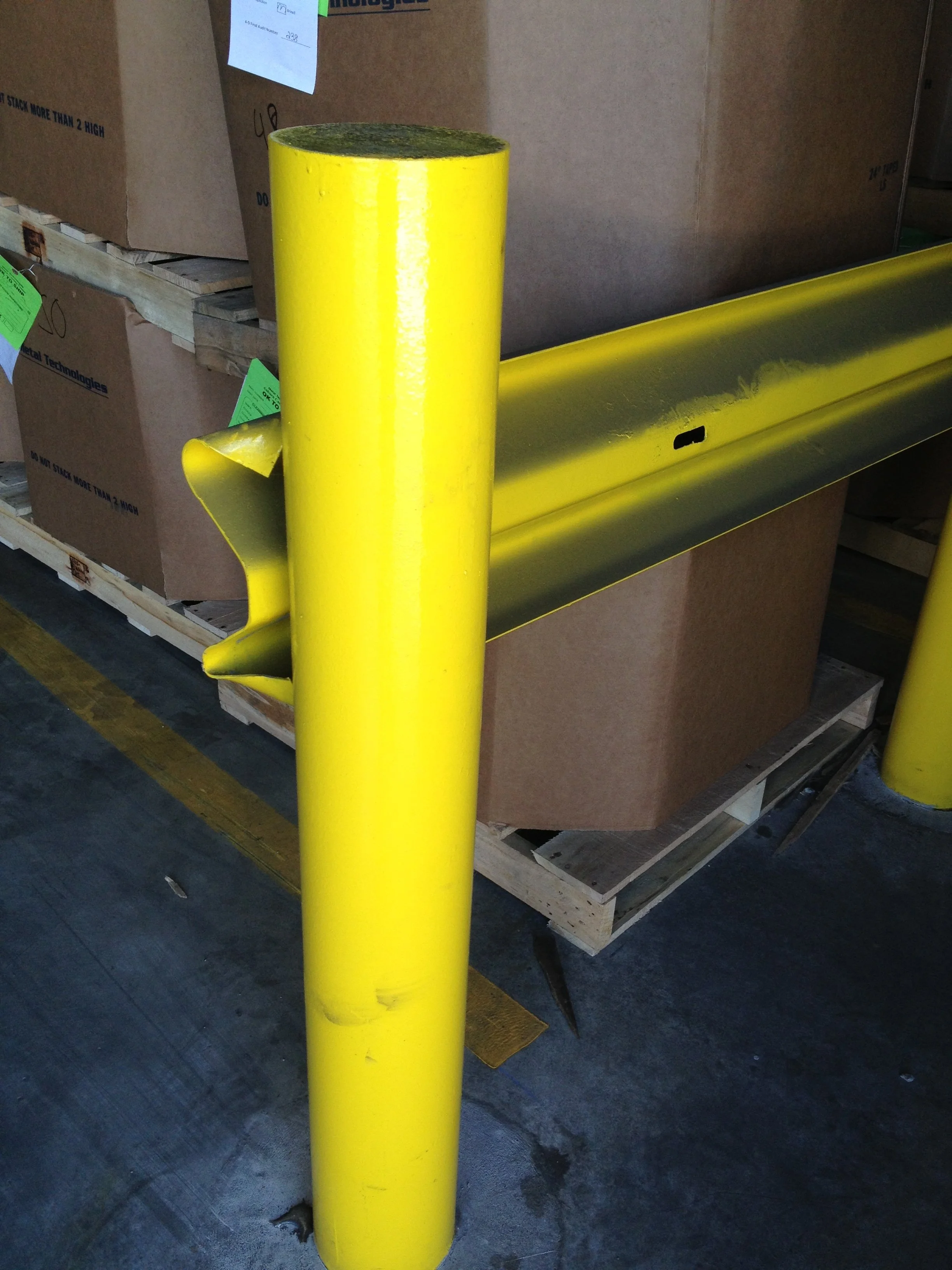 Steel safety bollard and guardrail system fabricated for warehouse protection.