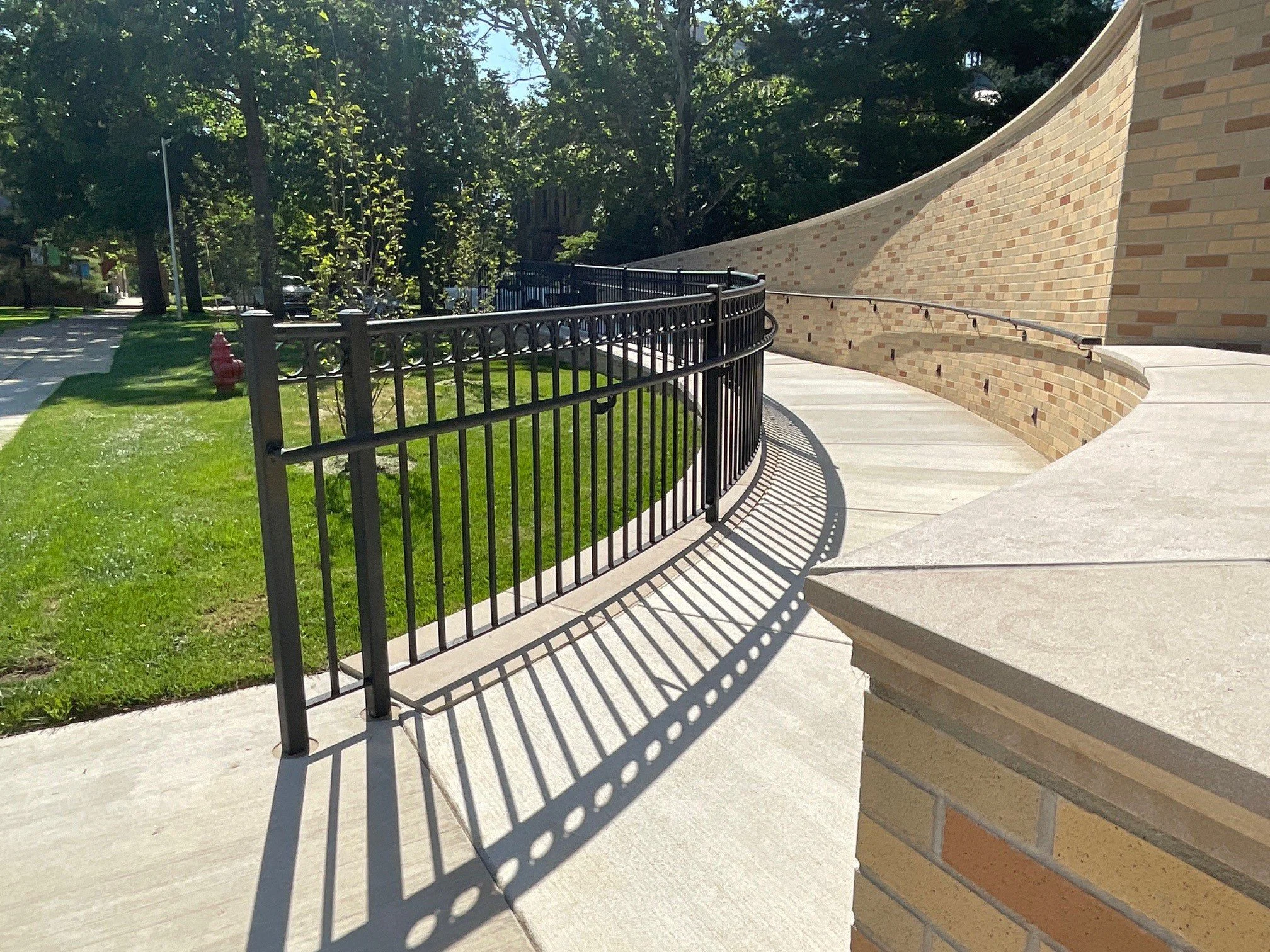 Custom Ornamental Steel Guardrail System Installed Along a Curved Accessibility Ramp at Indiana University South Bend.