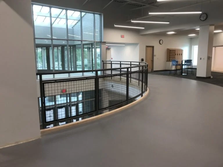 Curved Perimeter Railing Integrated with Upper-Level Circulation Overlooking the Pool Area.