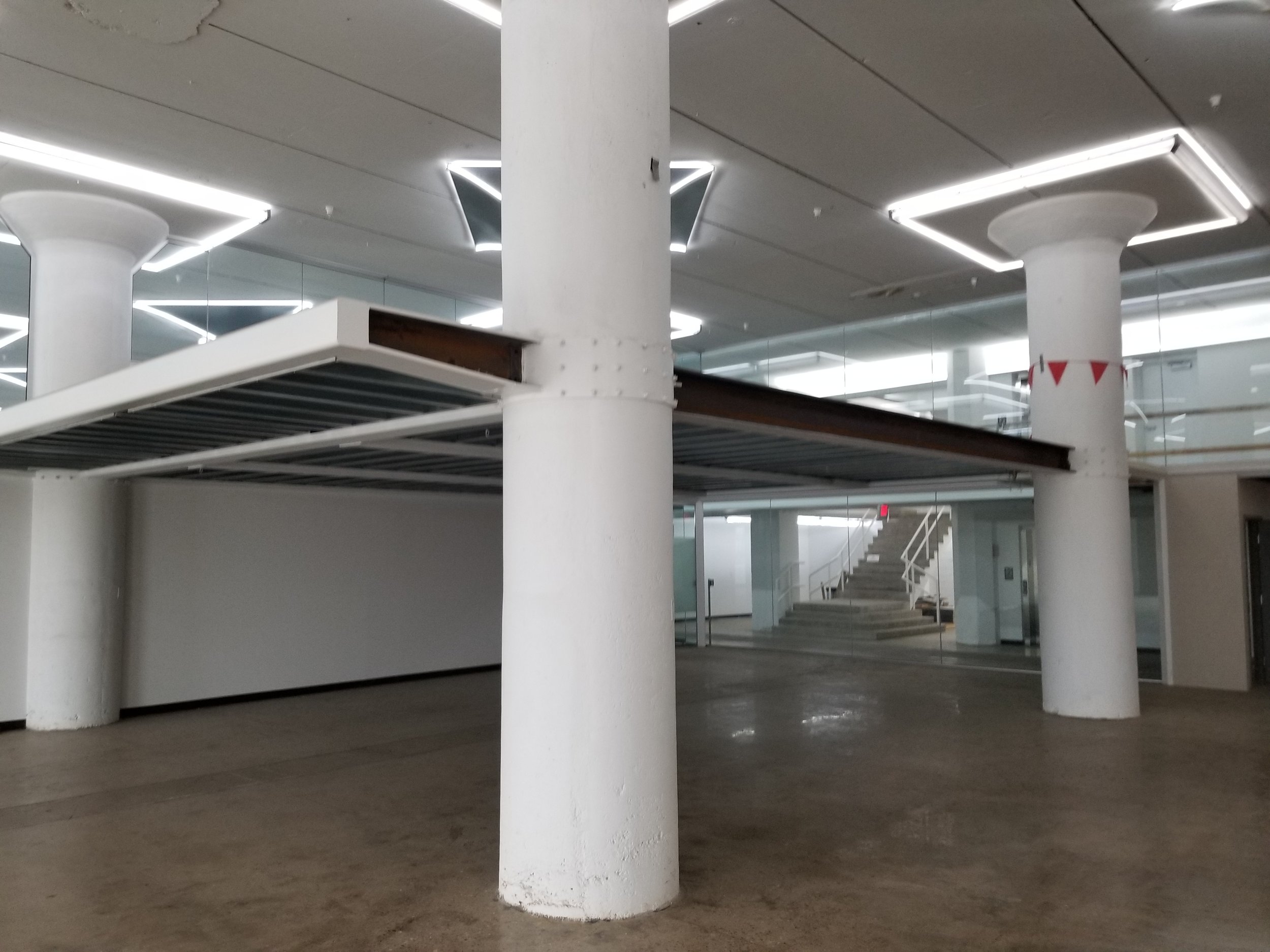 Exposed Structural Steel and Mezzanine Supports Preserving the Building's Industrial Heritage.