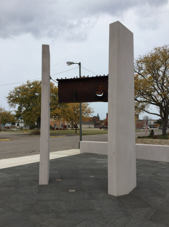 Vertical Steel Memorial Elements with Suspended Beam Fabricated as a Central Feature of the Plaza.