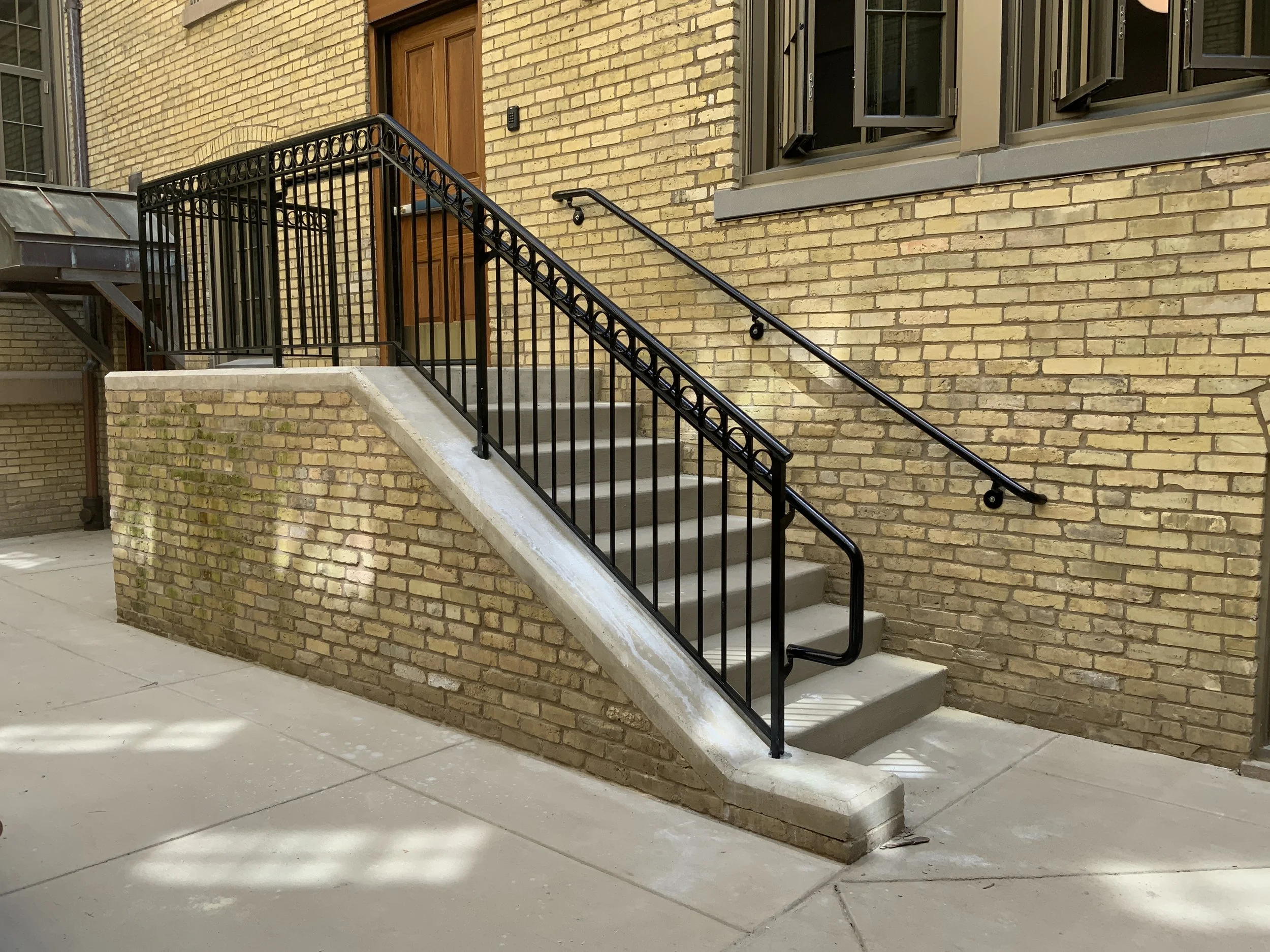 Exterior stair and accessibility ramp with custom metal railings.