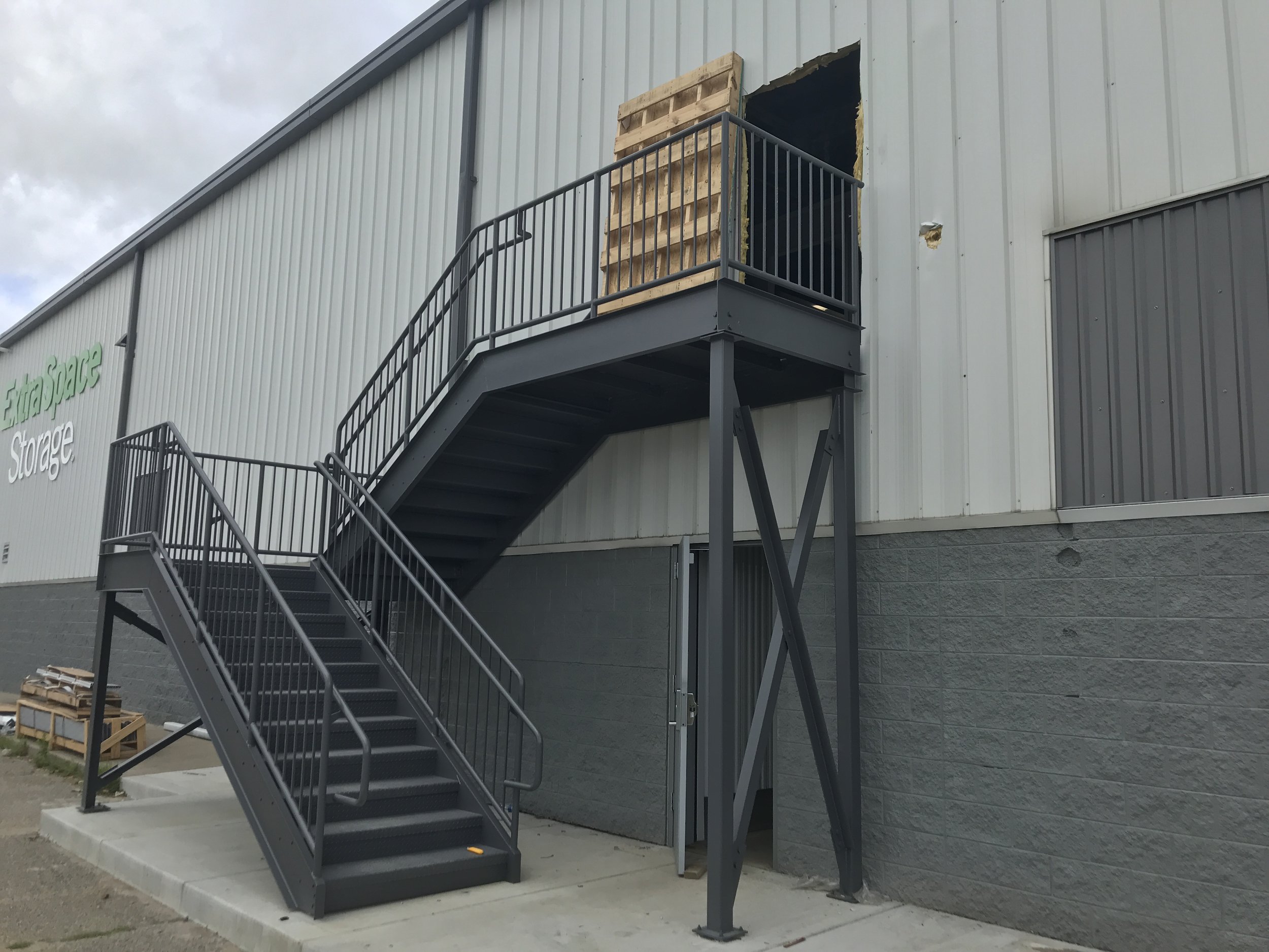Exterior steel stair and handrail system providing second‑floor access at a commercial building.