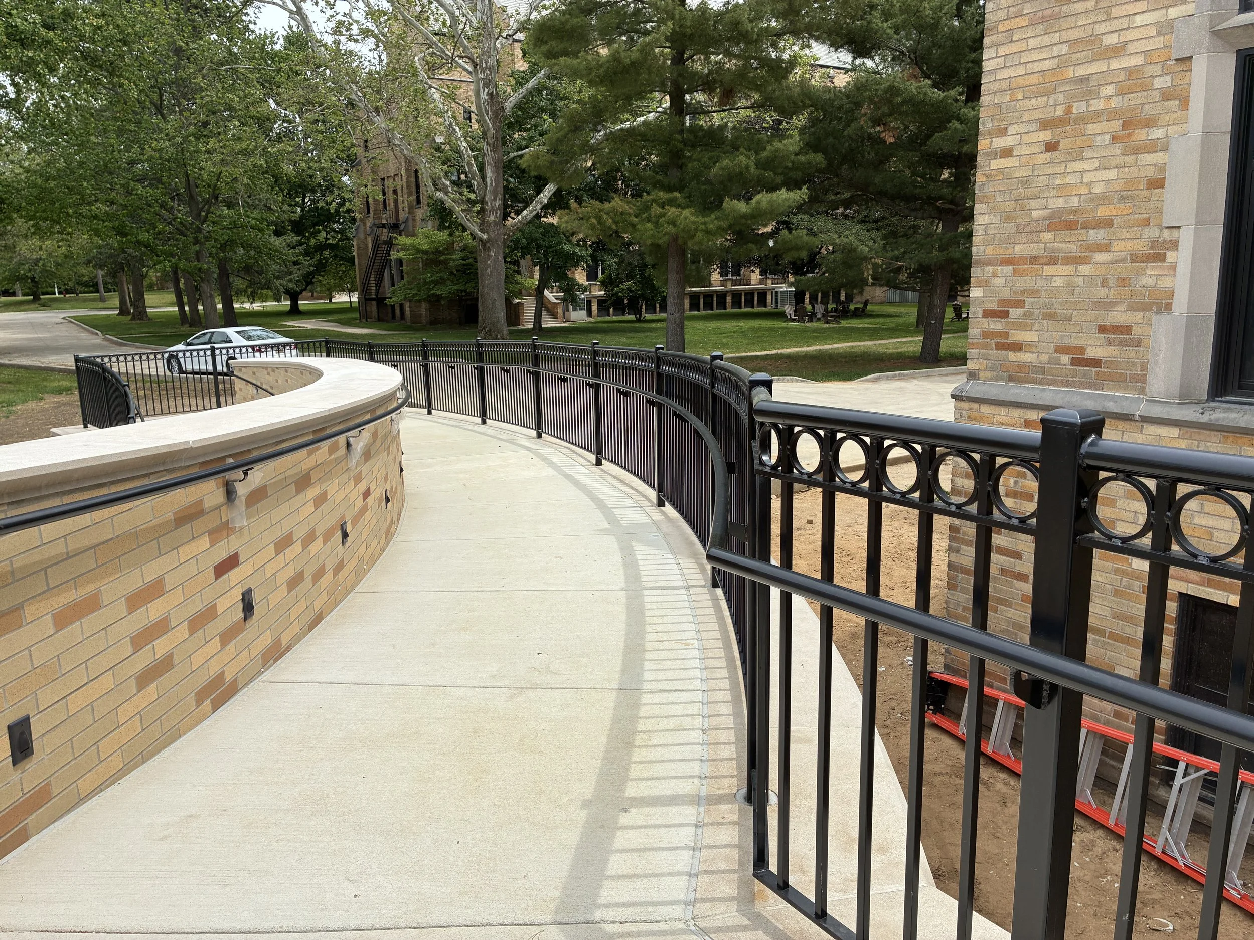 Custom Steel Railing System Integrated Along Curved Access Path at LeMans Hall.