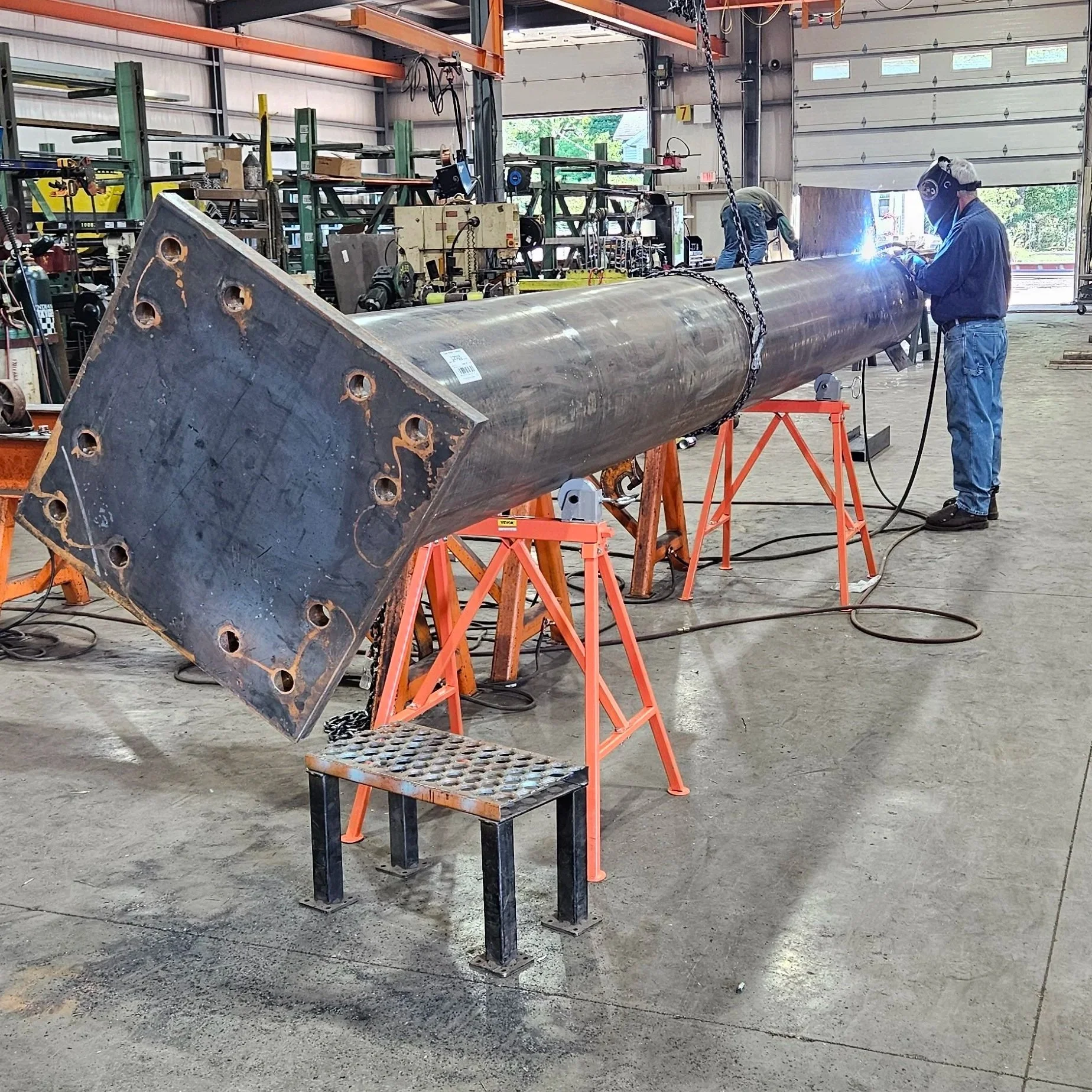 Welder fabricating a large structural steel assembly in the fabrication shop.