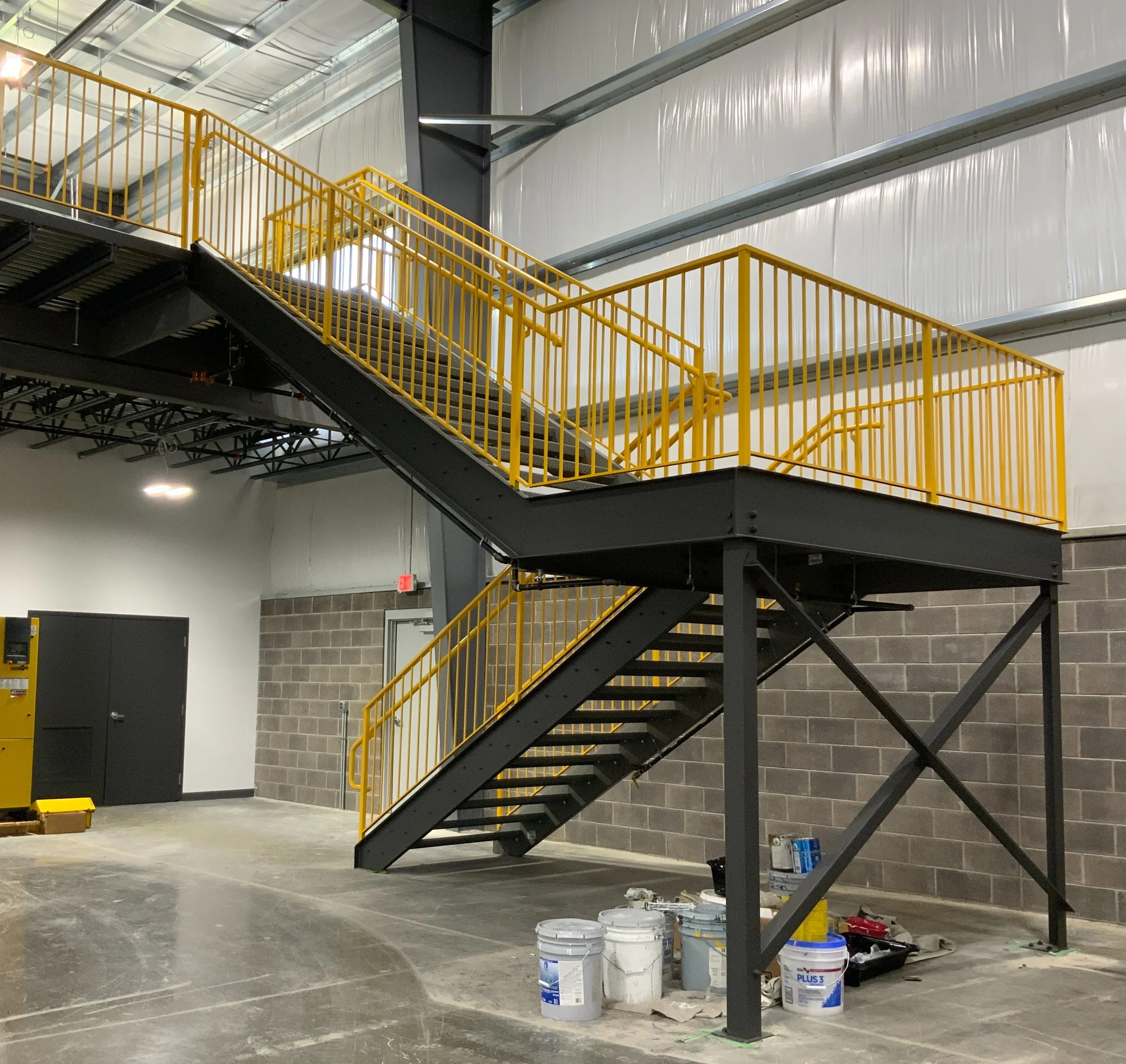 Industrial steel stair and safety railing system fabricated for interior facility access.