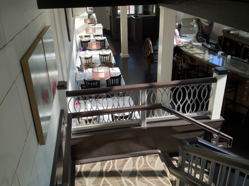 Ornamental steel stair and balcony railing system integrated into the historic interior.