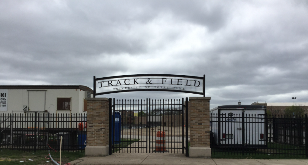 University of Notre Dame Track and Field curved metal entrance sign above black gates