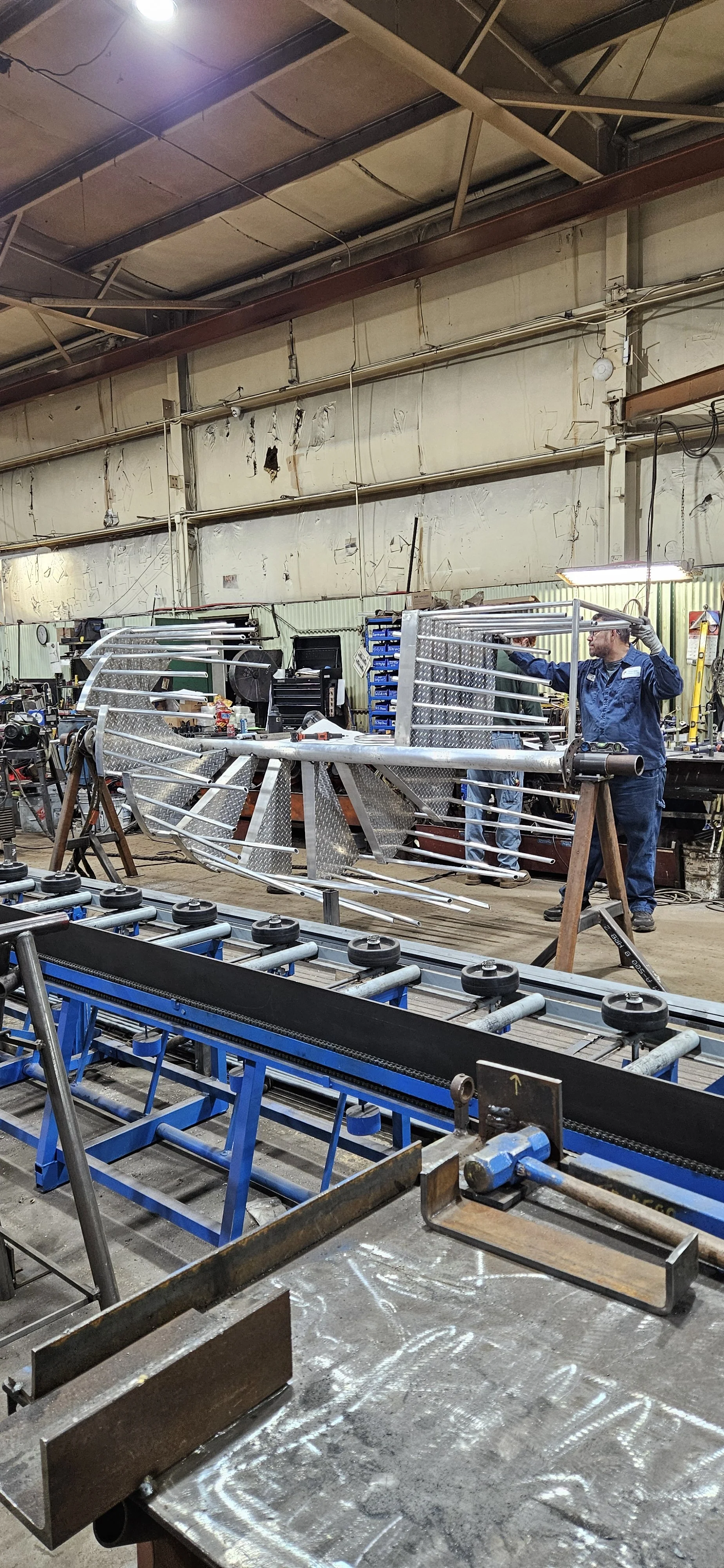 Steel spiral staircase components being assembled in the fabrication shop.
