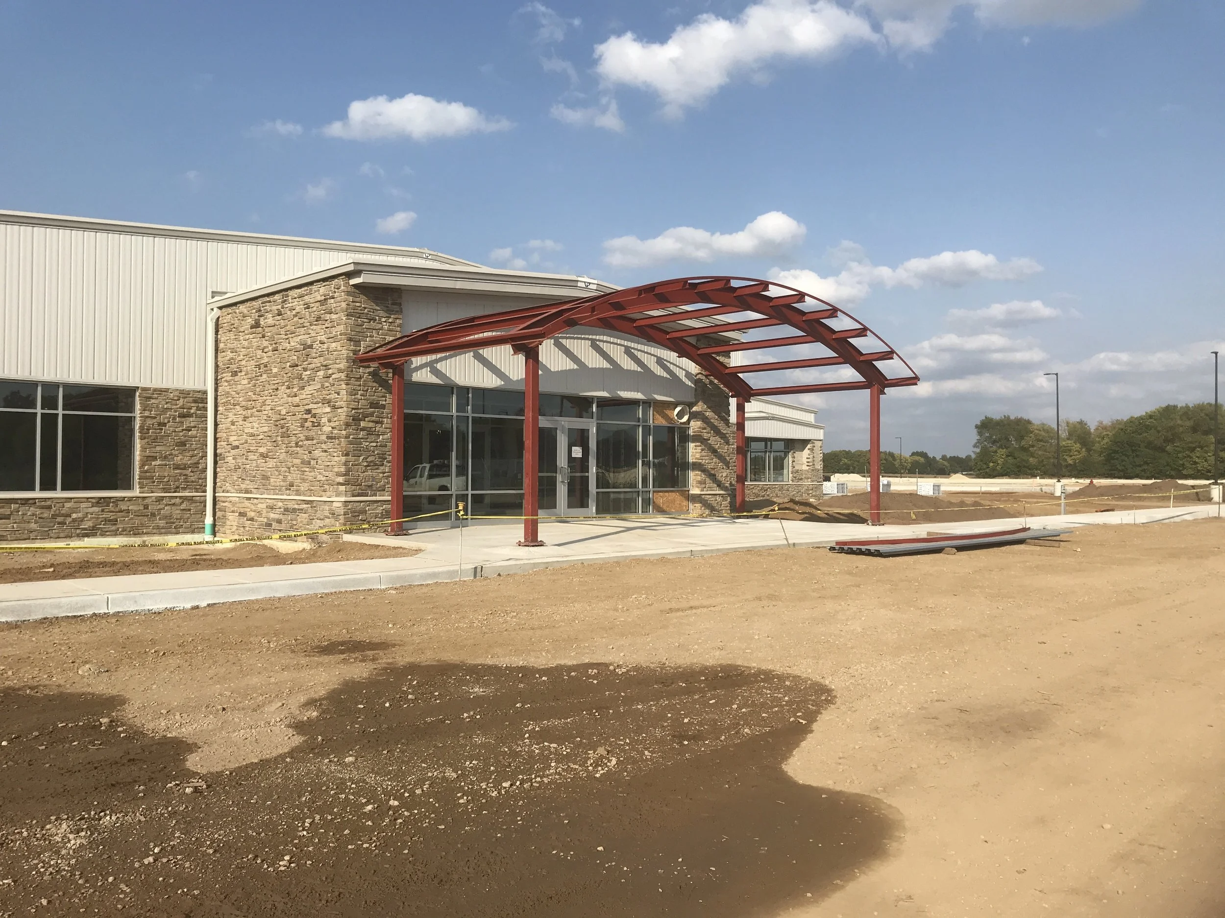 Structural steel entry canopy under construction at commercial building.