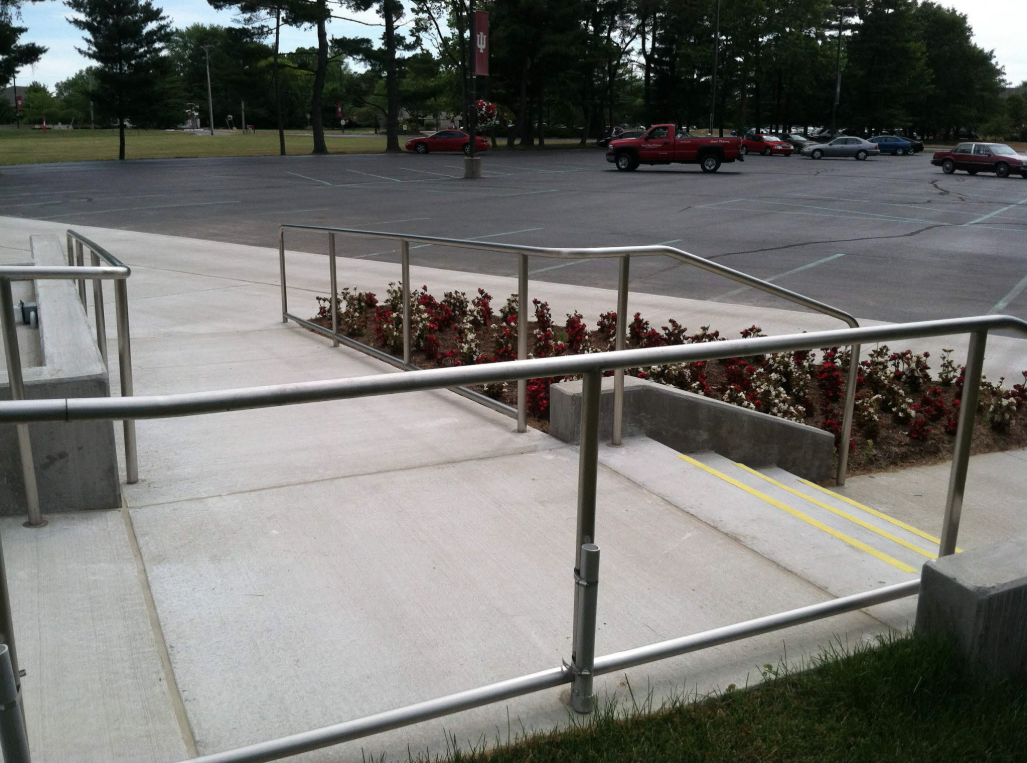 Fabricated steel handrails supporting accessible ramp access and pedestrian circulation adjacent to the outdoor pavilion at Indiana University Kokomo.