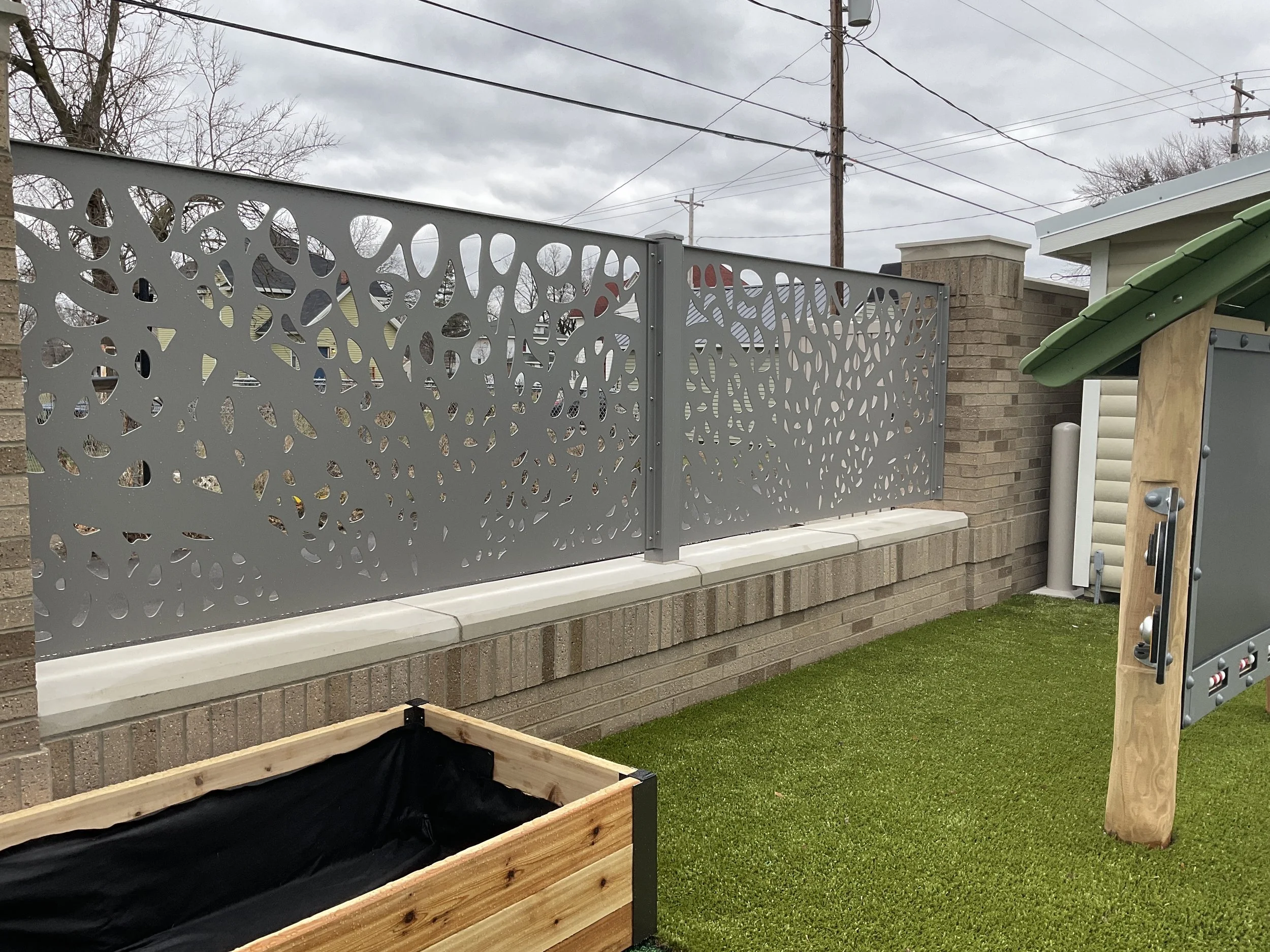 Custom Metal Fencing Coordinated with Landscape Elements Throughout Playground.