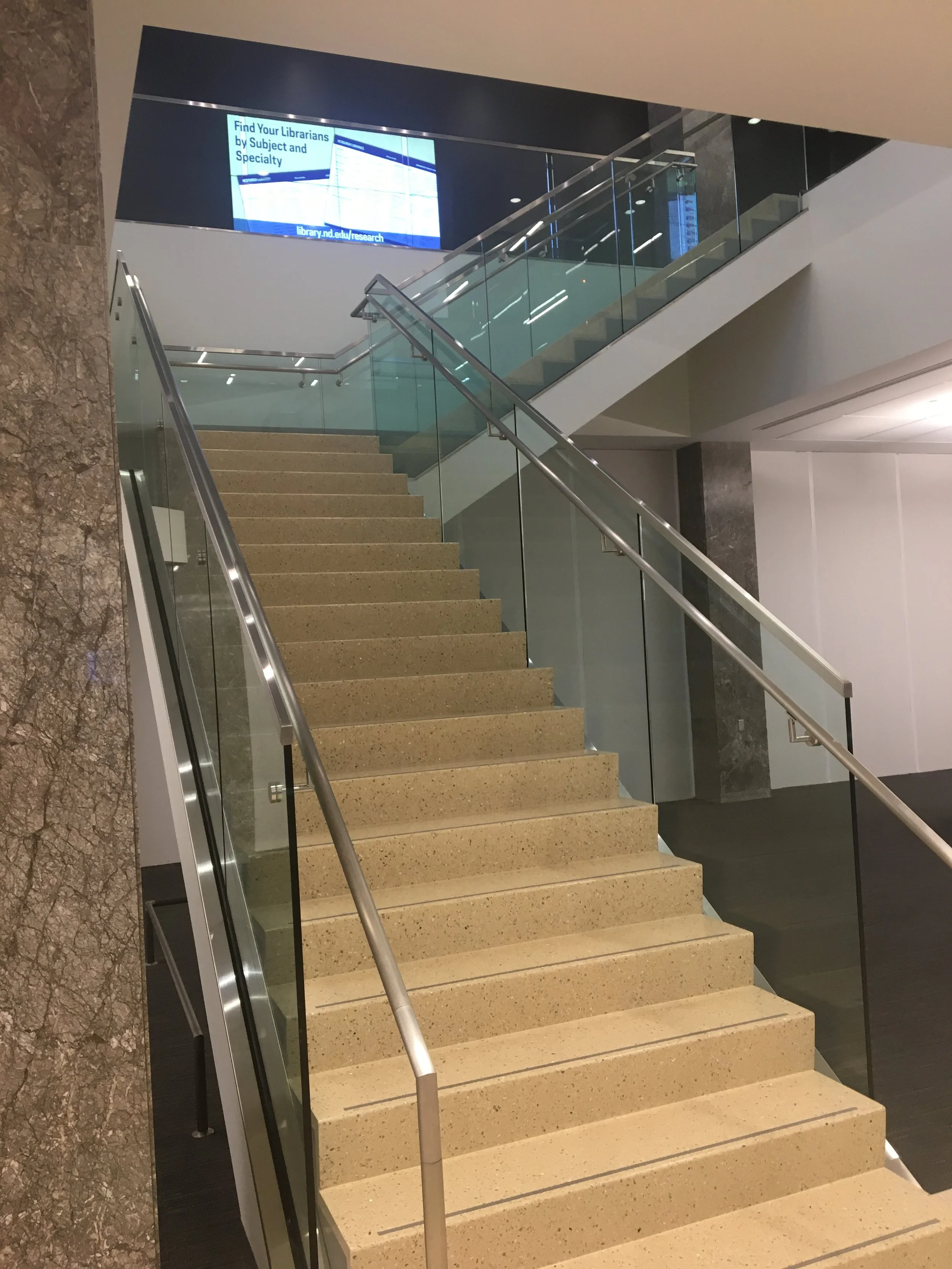 Architectural Glass Railings Providing Open Sightlines Throughout the Multi-Level Interior.