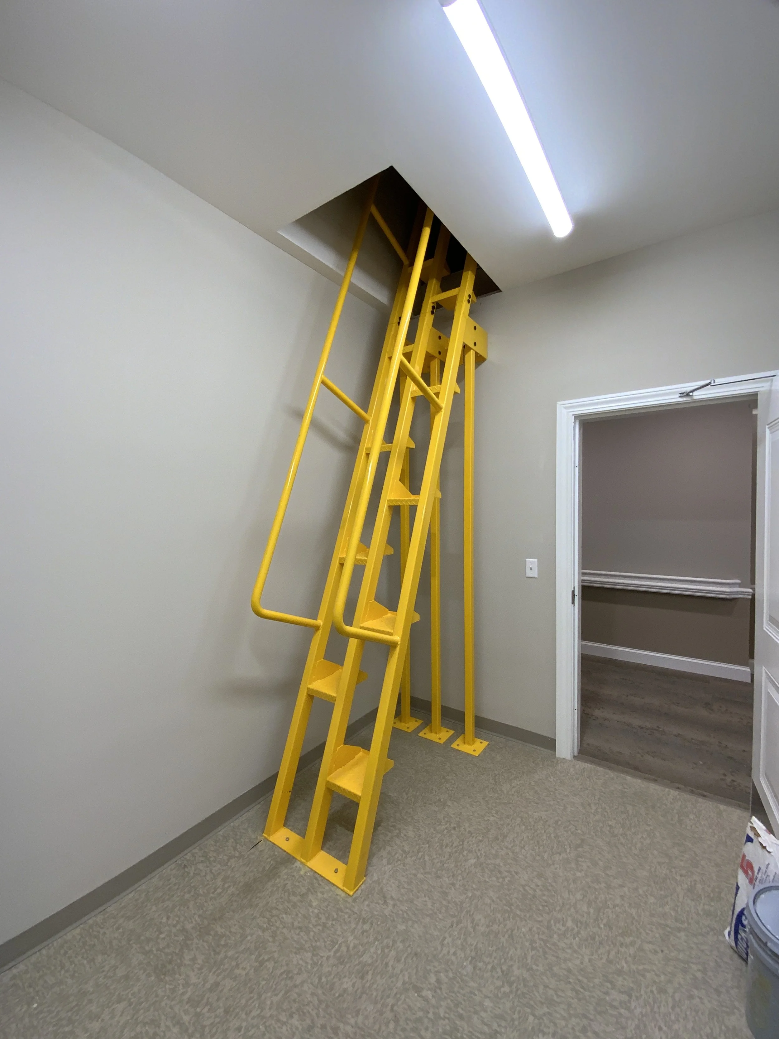 Interior access ladder providing maintenance access to ceiling hatch.