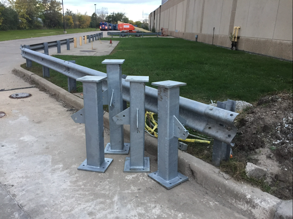 Steel guardrail and protective posts installed for site safety.