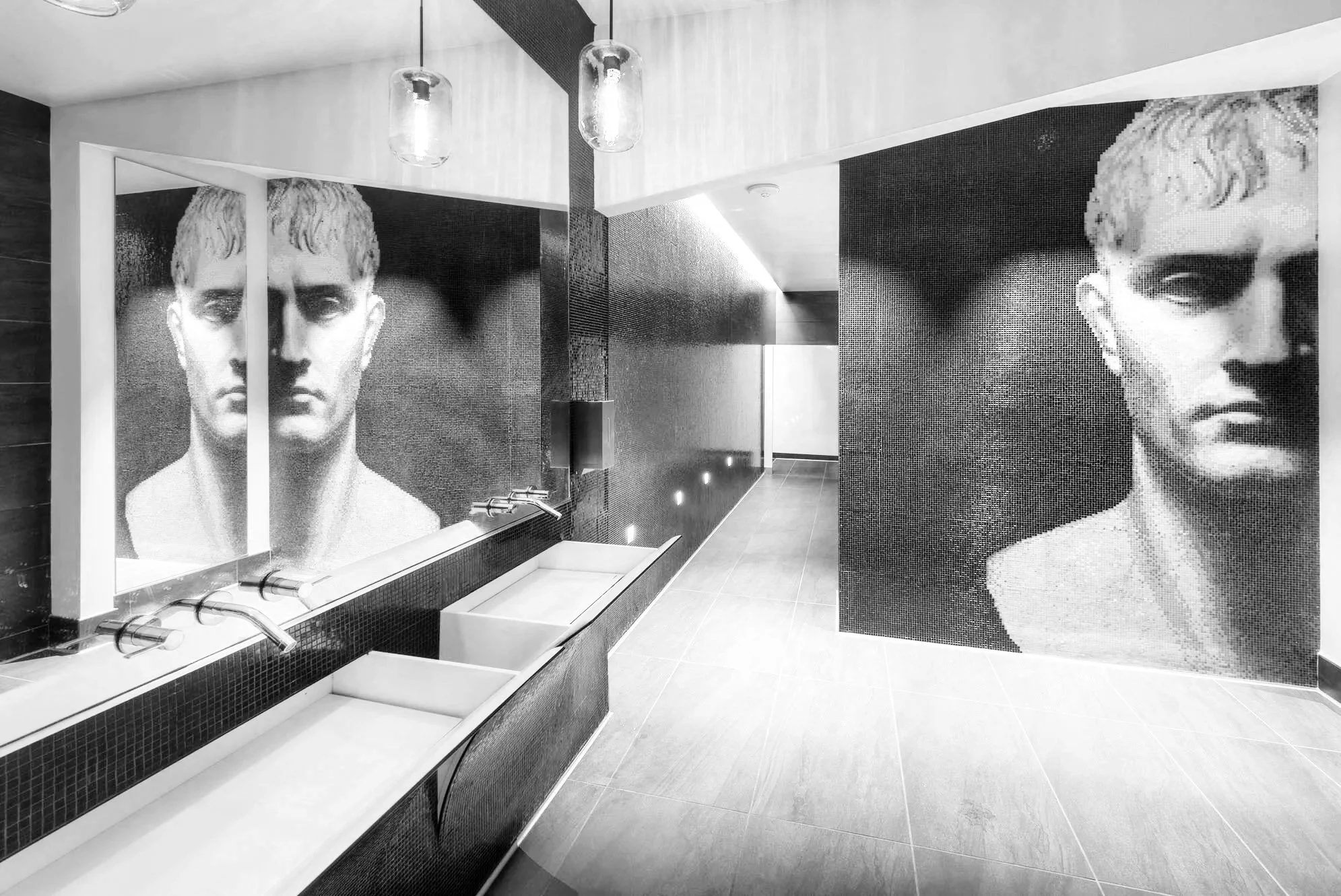 A modern interior with two large black-and-white portraits of a young man on the walls.