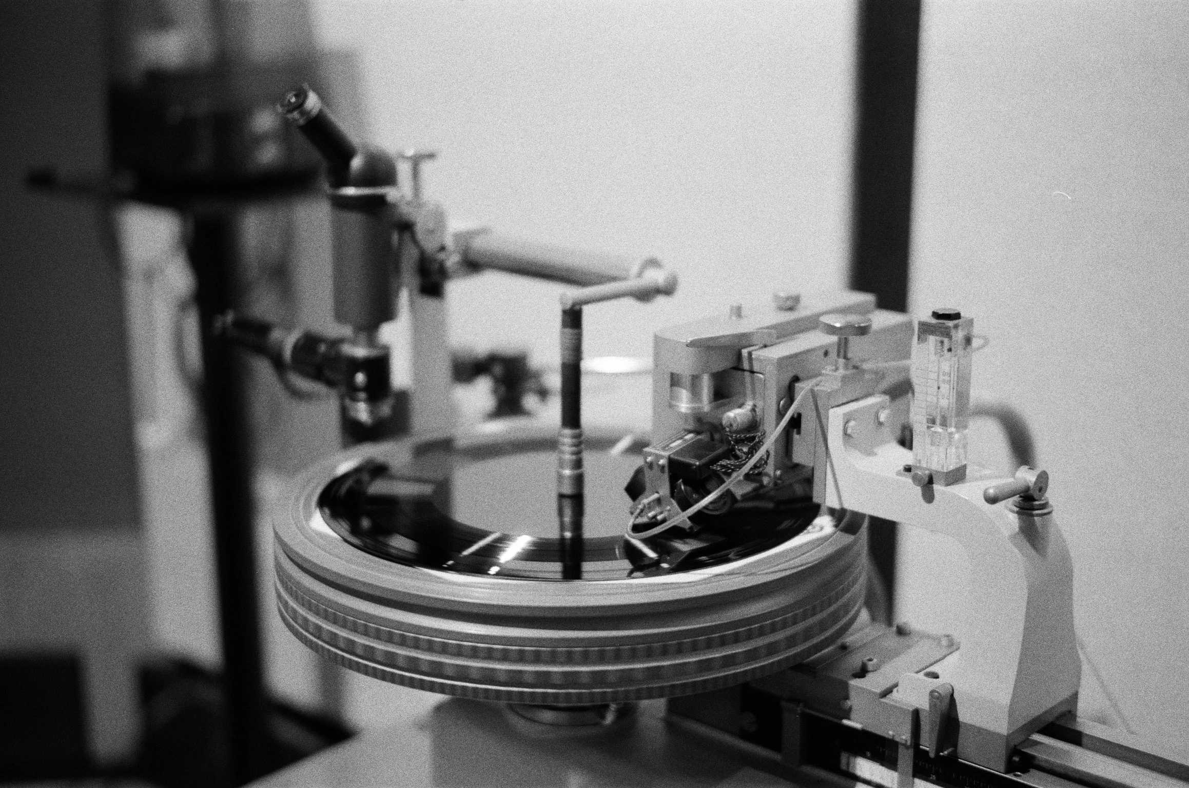 Close-up of a scientific instrument with a rotating platform, mechanical components, and precision parts, in black and white.