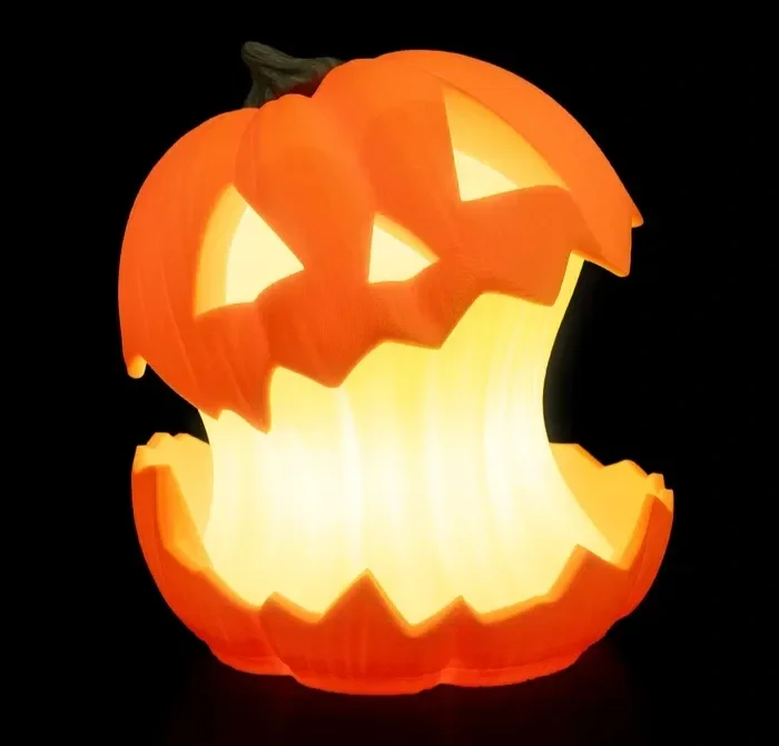 A carved pumpkin with a face, lit from inside, resembling a classic Halloween jack-o'-lantern.