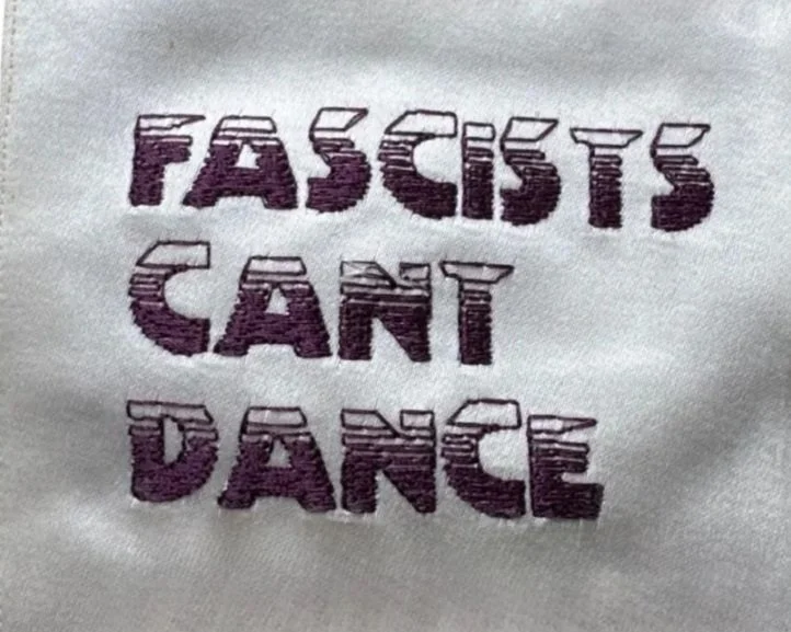 Text on fabric that reads "FASCISTS CAN'T DANCE" with a 3D block lettering style.