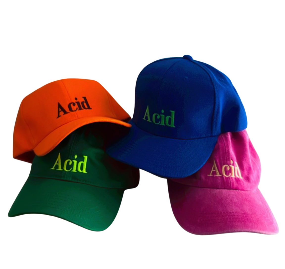 Four colorful baseball caps with the word 'Acid' embroidered on the front, in orange, blue, green, and pink colors.