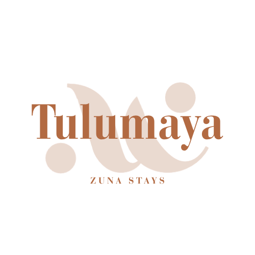 Logo for Tu Maya Zuna Stays, featuring stylized text with brown and tan colors.