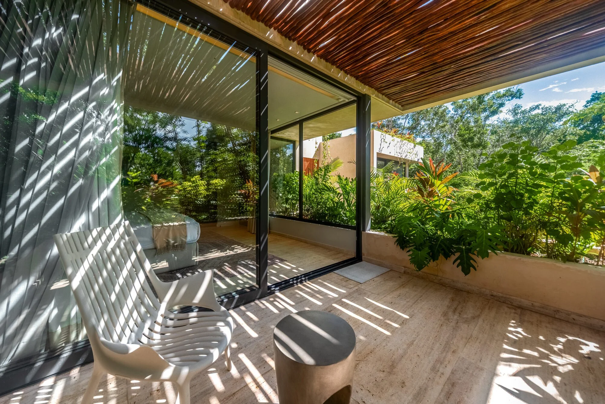 Bedroom opening to a private jungle terrace at Villa Caimán, Tulum