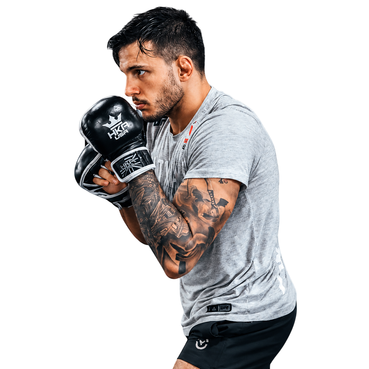 Young male MMA fighter, Luigi Vendramini, in a fighting stance with gloves, tattoos, and casual sportswear, focused and ready for action.