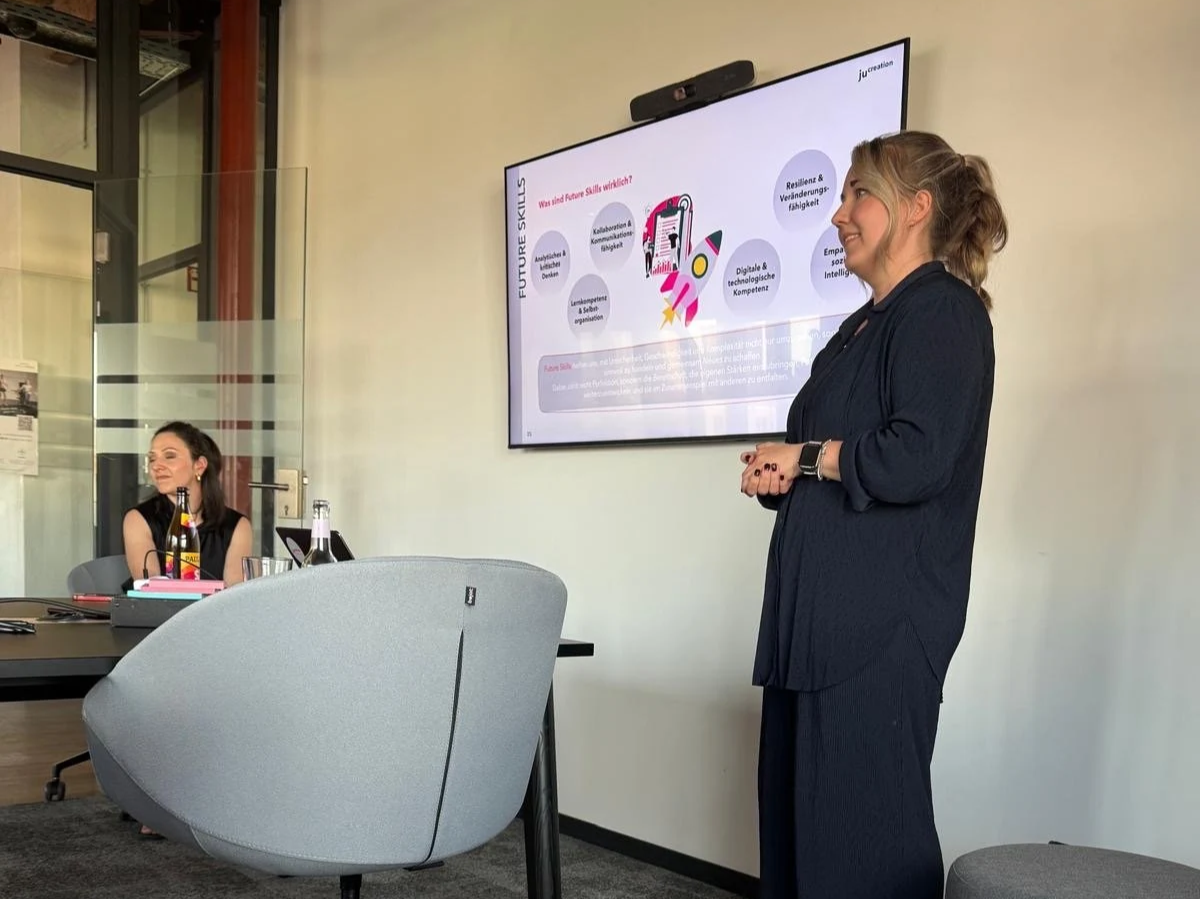 Juliane Superka steht während einer Präsentation zum Thema Future Skills vor einem Bildschirm.