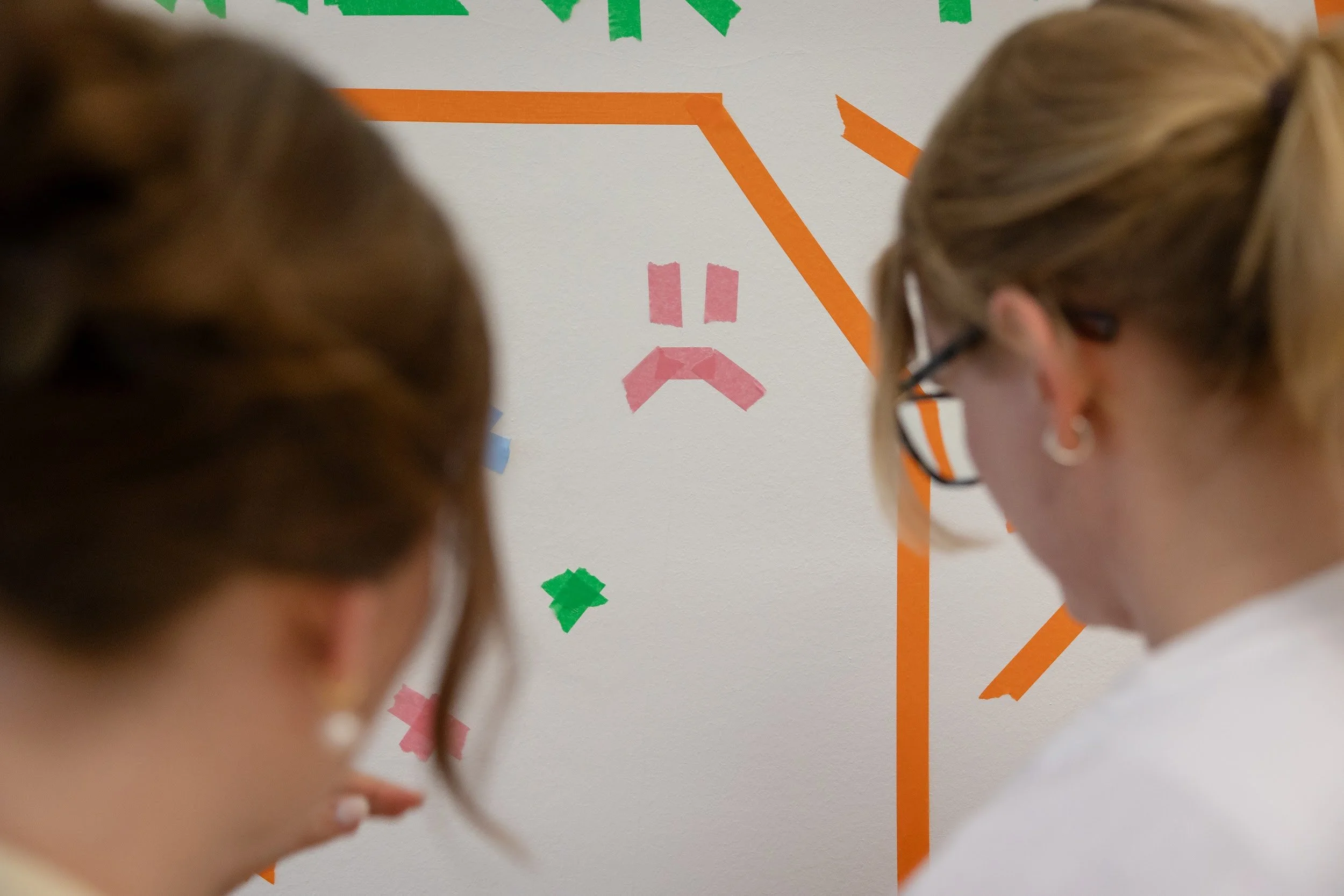 Josephine Arndt und Neele Kämpfert tapen die Wand.