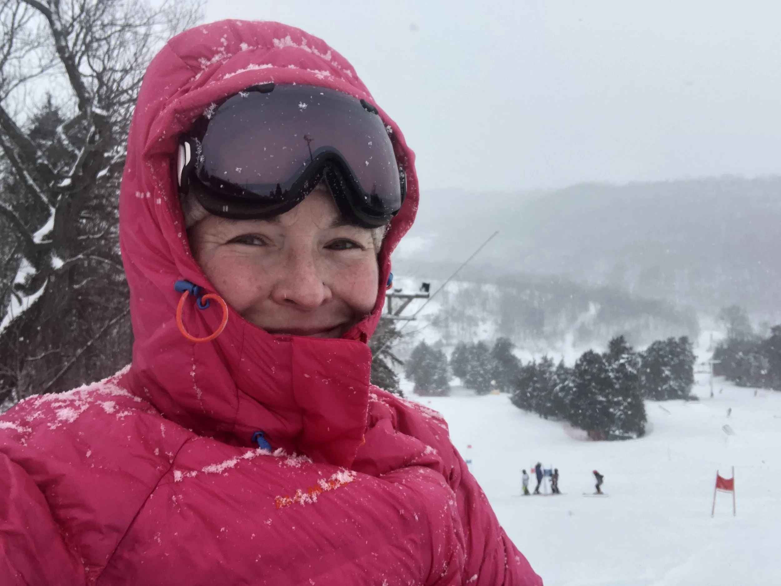 Selfie of Mya Schaefer coaching alpine skiing on a cold January day. Standing along the edge of a Giant Slalom course.