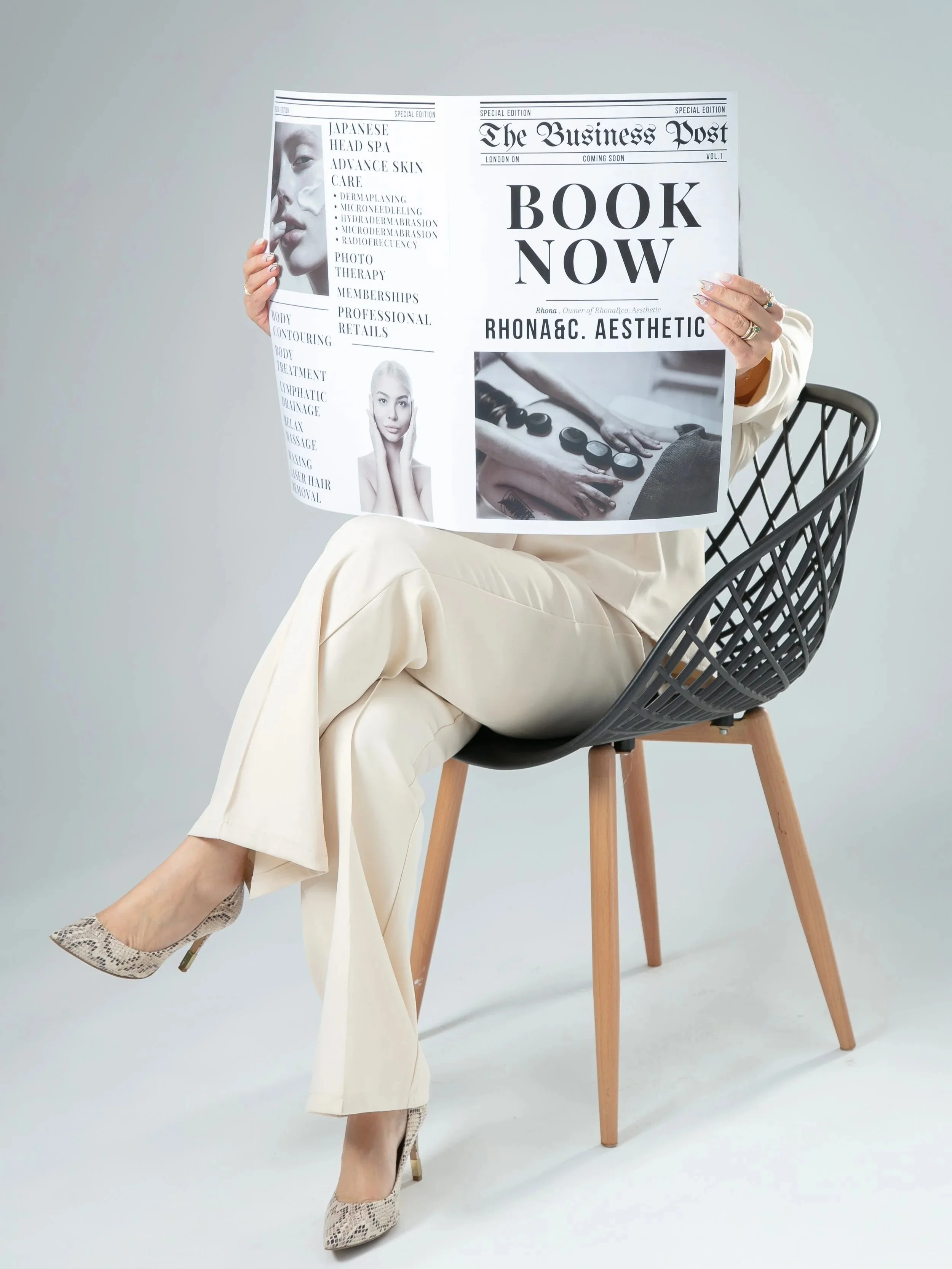 Person sitting on a chair covered with a newspaper, revealing only their ankles and shoes, with the rest of their body hidden behind the newspaper.