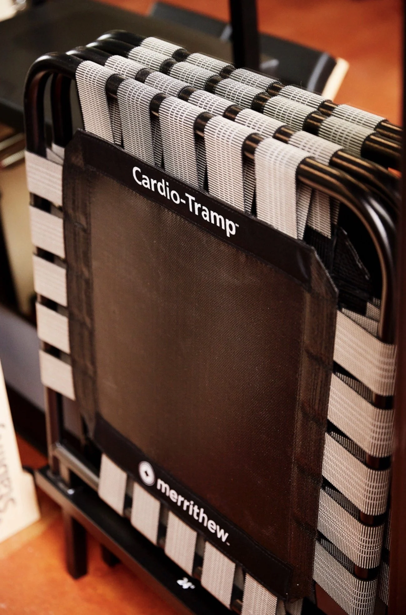Group of people exercising on Pilates reformer machines in fitness studio Reformacore, with brick walls and modern lighting.